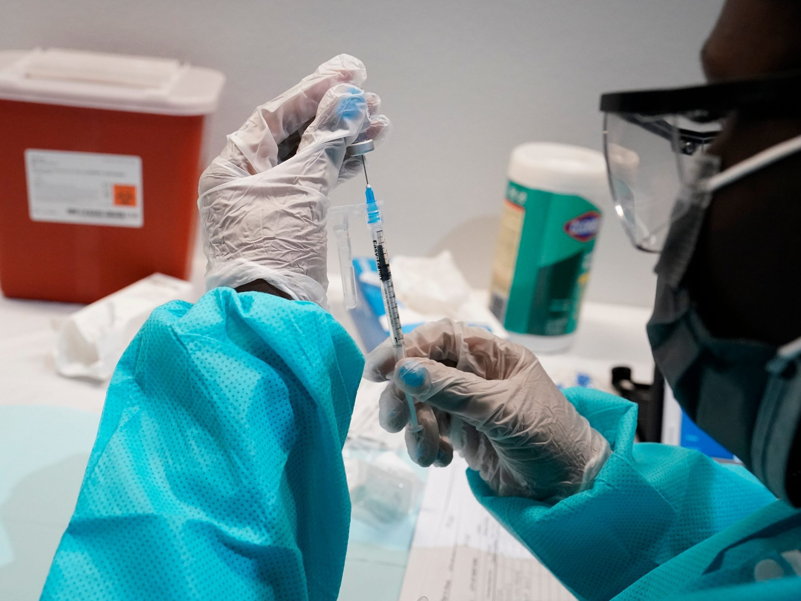 A health care worker fills a syringe with the Pfizer COVID-19 vaccine.