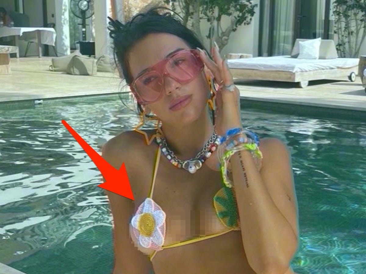 Dua Lipa poses in sunglasses and a swimsuit in front of a pool with an arrow pointing to her swimsuit.