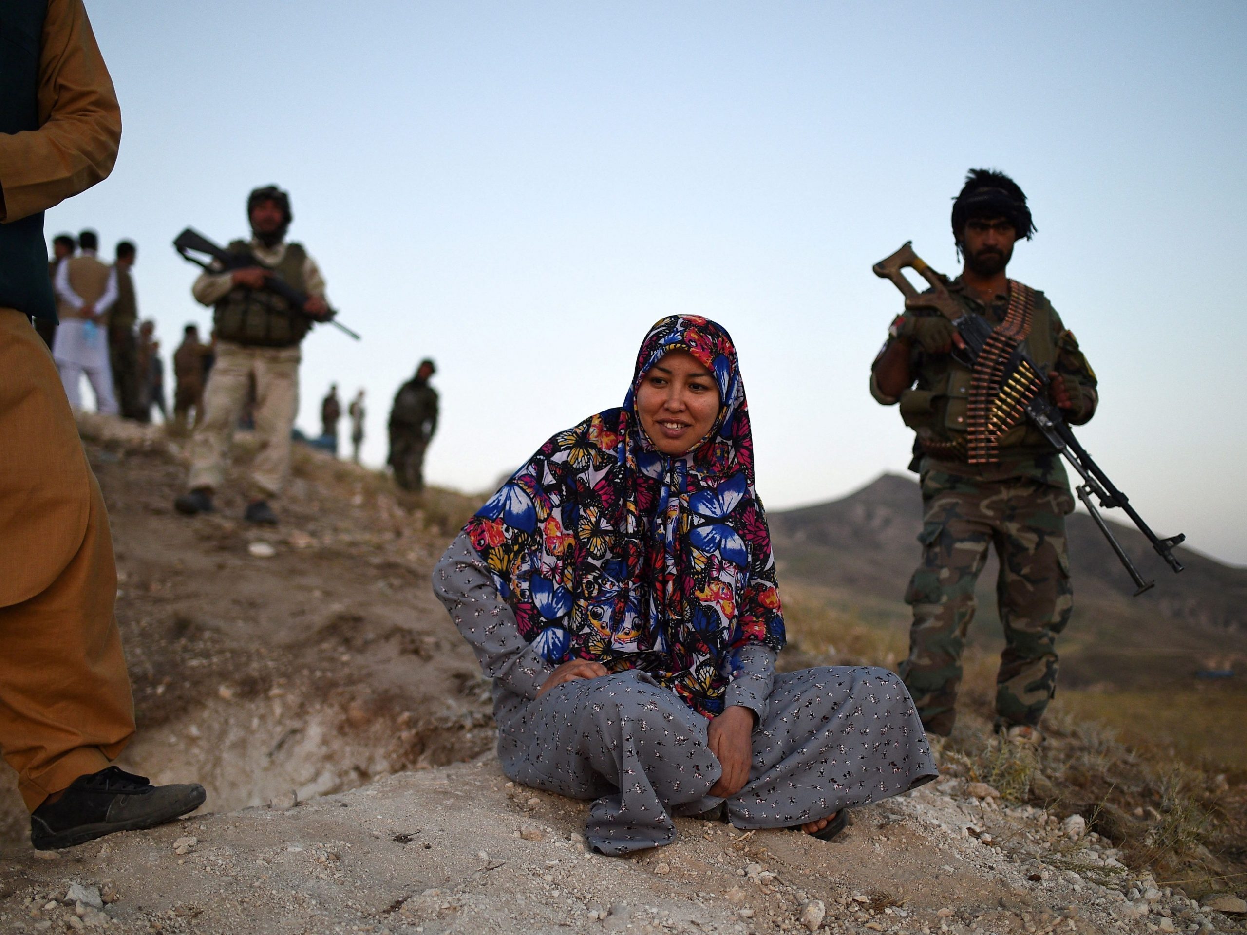 This photograph taken on July 14, 2021 shows Salima Mazari (C), a female district governor in male-dominated Afghanistan, looking on from a hill while accompanied by security personnel near the frontlines against the Taliban at Charkint district in Balkh province.