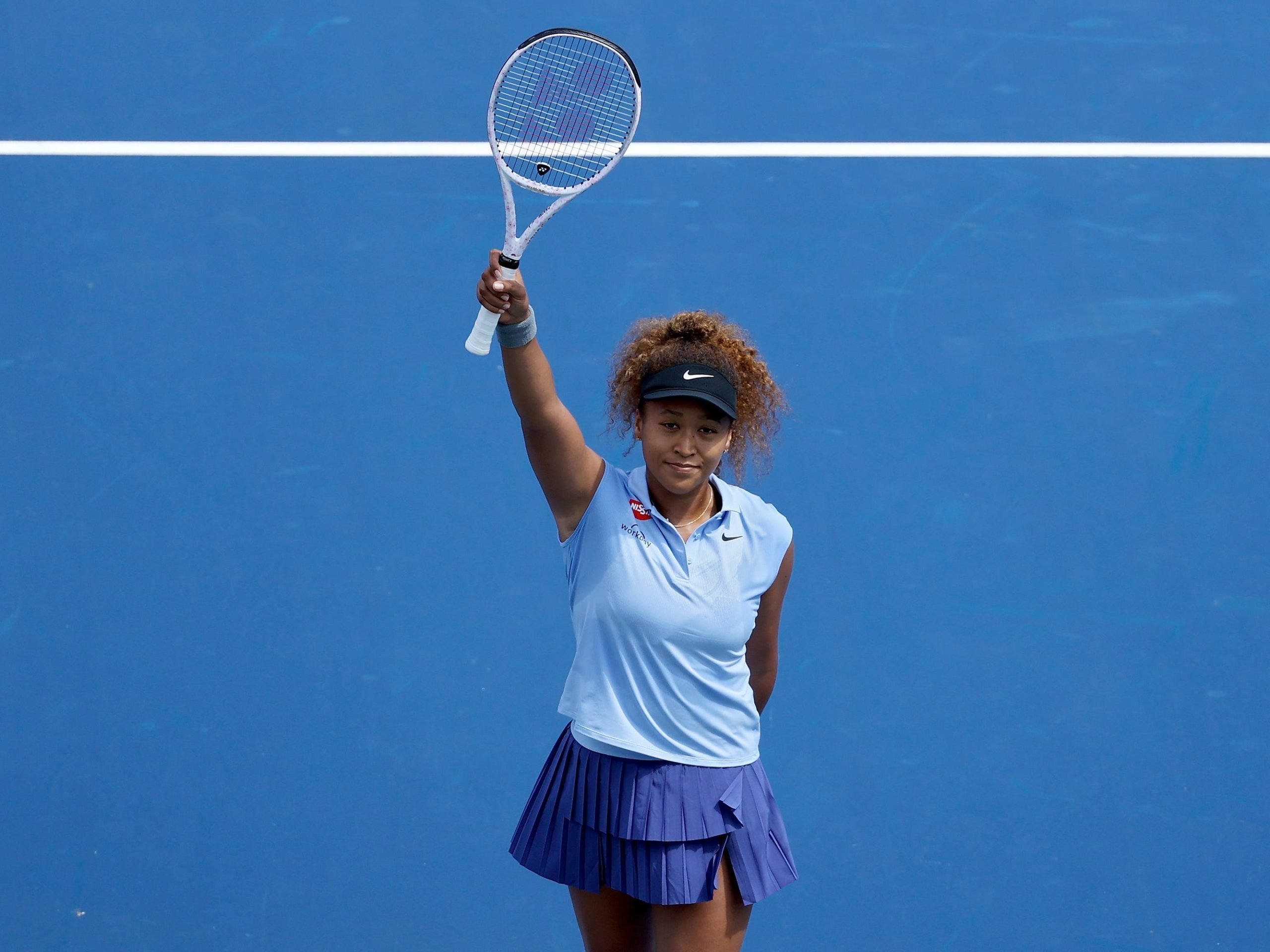 Naomi Osaka raises her racquet after defeating Coco Gauff