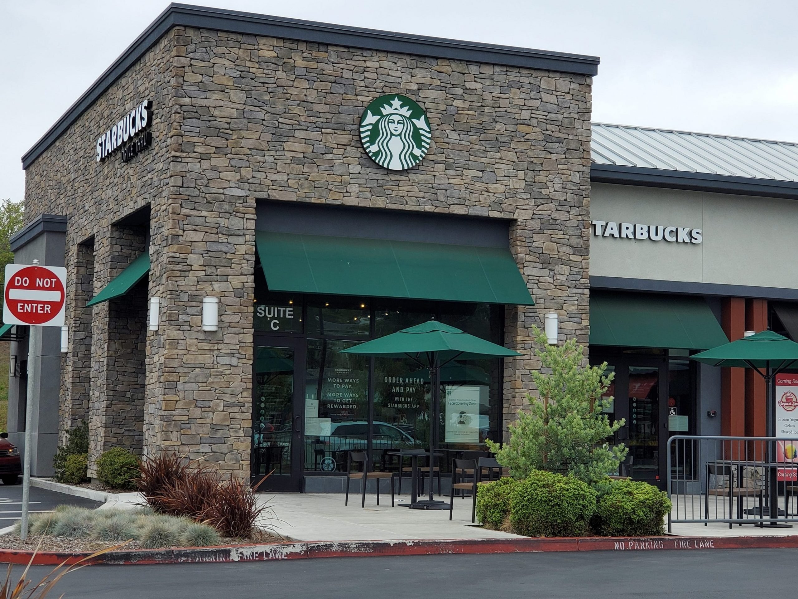 Front view of the entrance to a Starbucks coffee shop with the company signage above in Walnut Creek, California April 2021