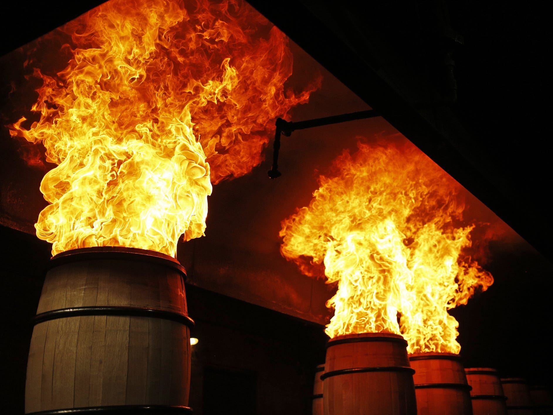 Bourbon barrels with flamed emerging from the tops as part of the charring process