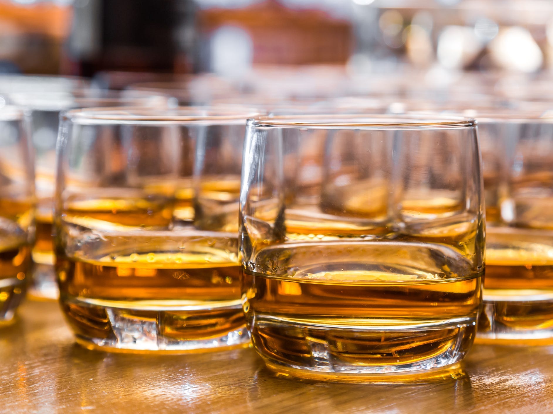 Many rocks glasses of straight whiskey on a table