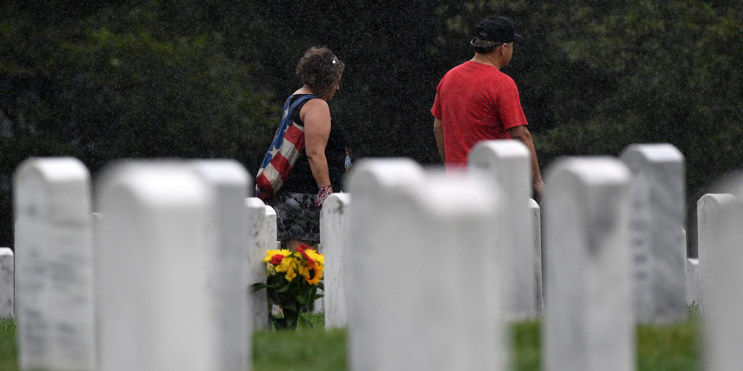 A man and a woman walk amongst the headstones of those killed during the wars in Iraq and Afghanistan in Section 60 of Arlington National Cemetery on August 16, 2021 in Arlington, Virginia.