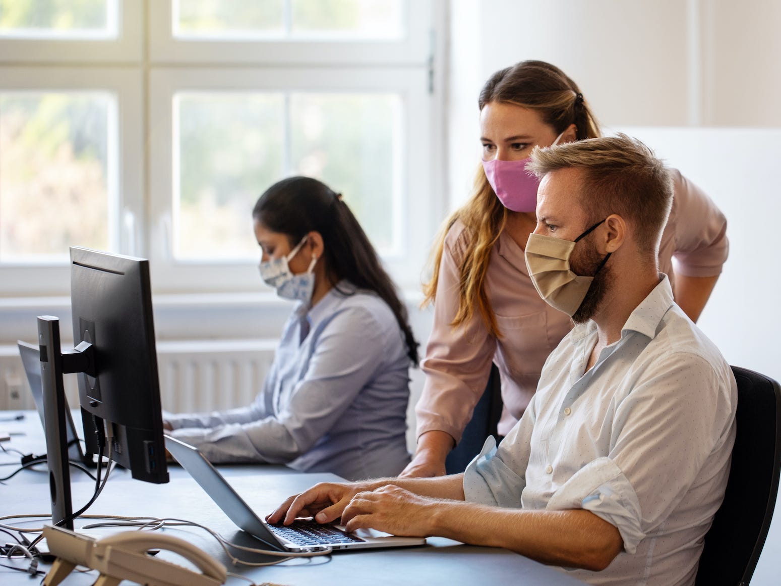 workers in an office looking at a computer screen together