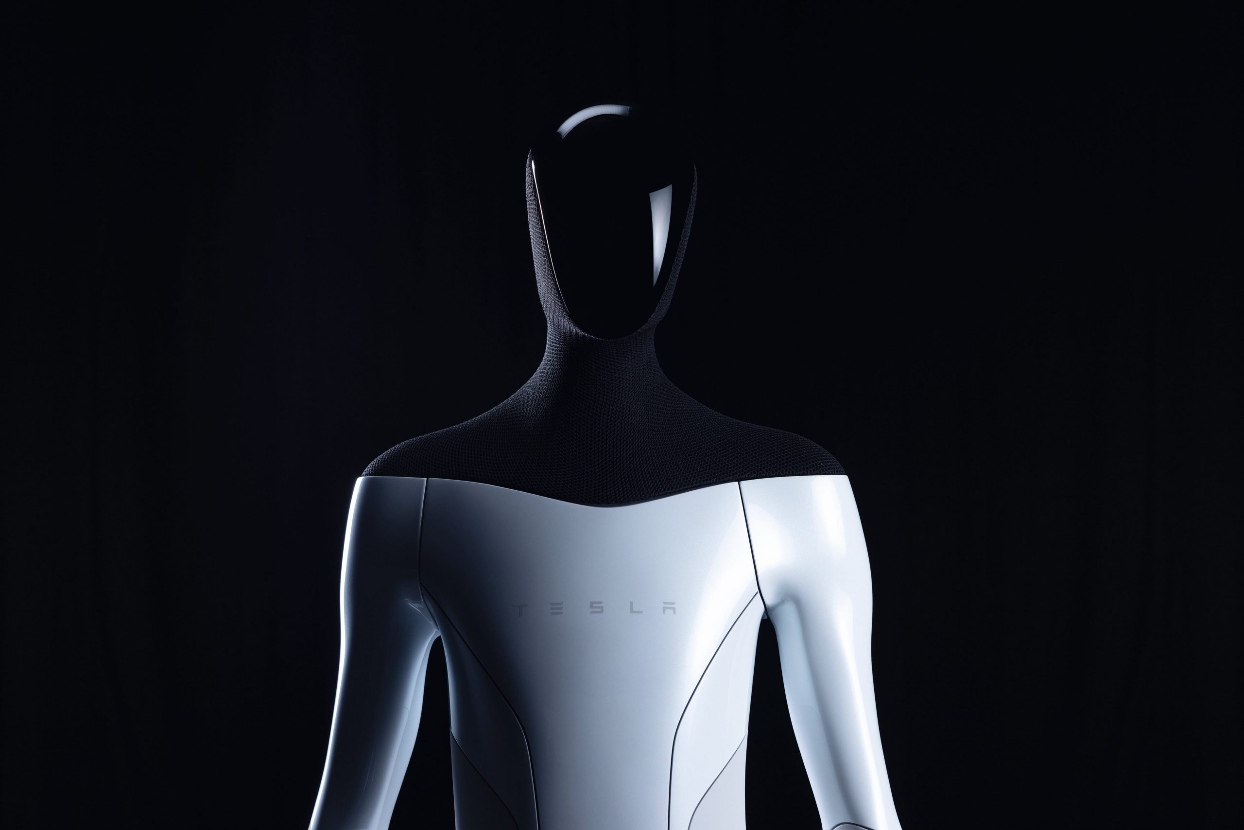 A rendering of the Tesla Bot with a faceless human form and a Tesla logo on its chest