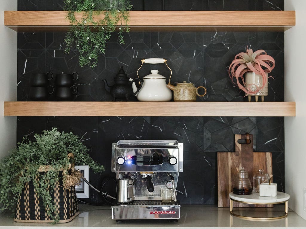 Floating wood shelves hanging on a black wall.