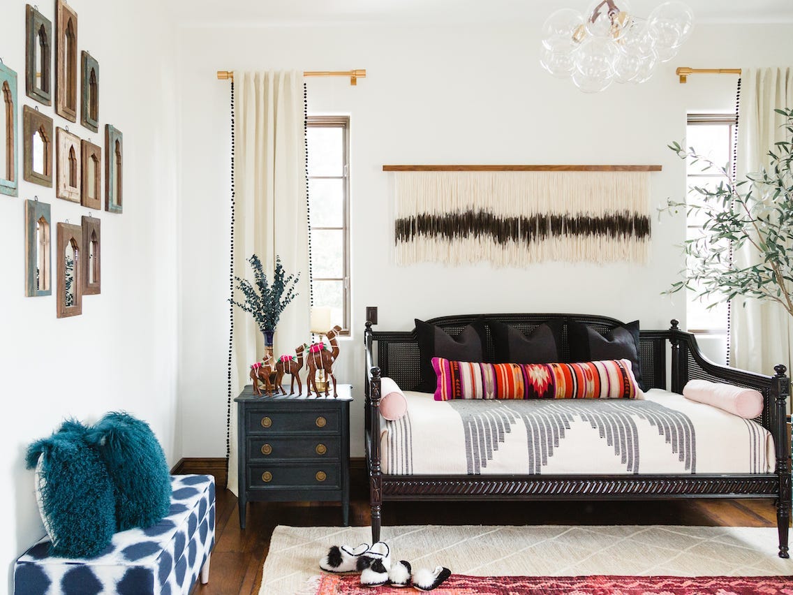 A white bedroom with a black sleigh bed.