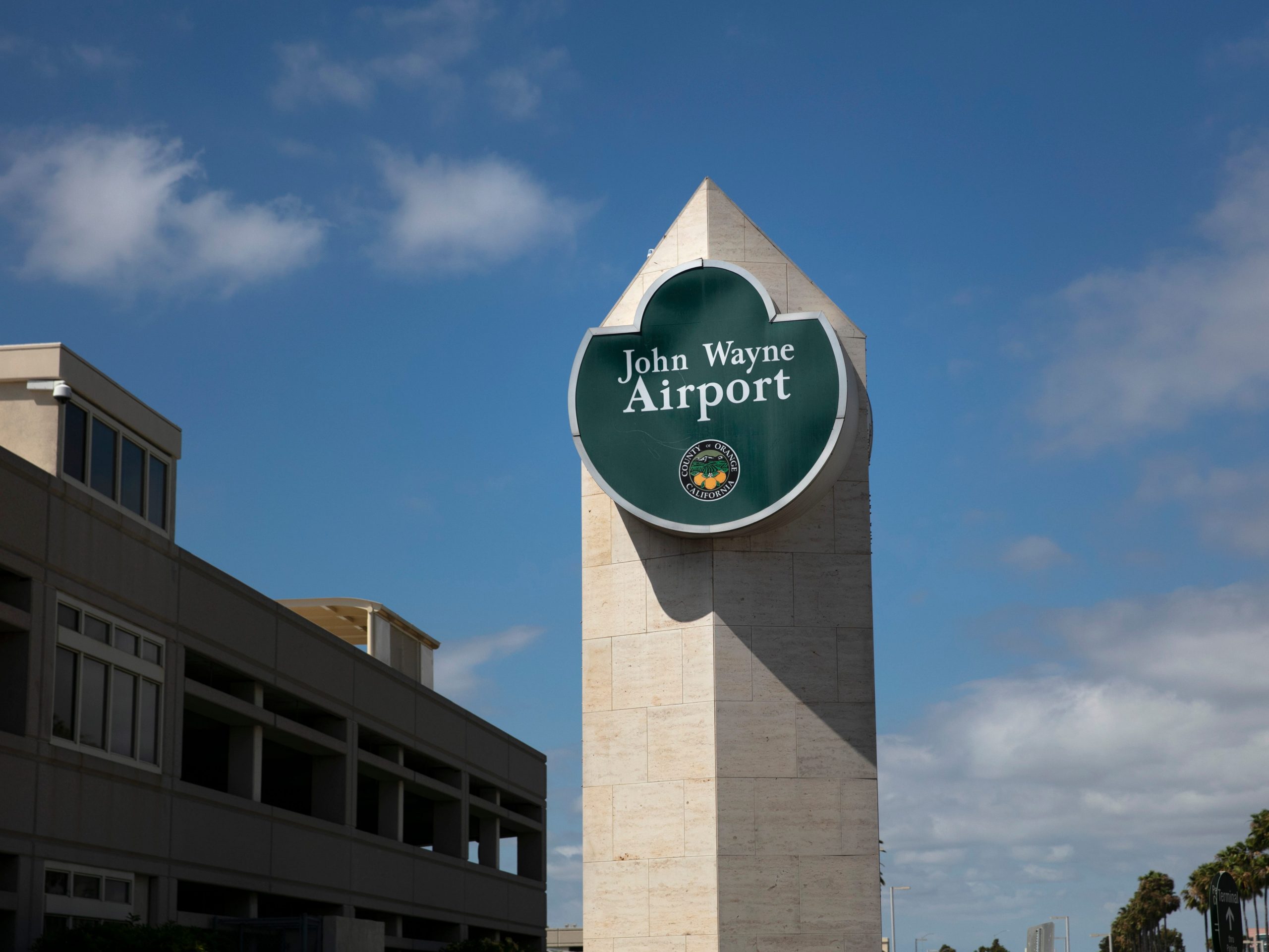 A John Wayne Airport sign fixed to a large pillar