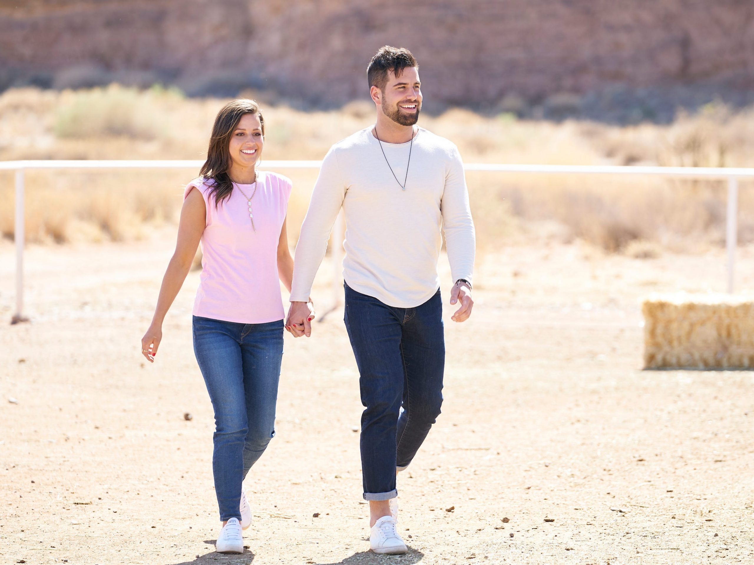 Katie Thurston and Blake Moynes hold hands while walking across a field in this still from the season finale of "The Bachelorette."