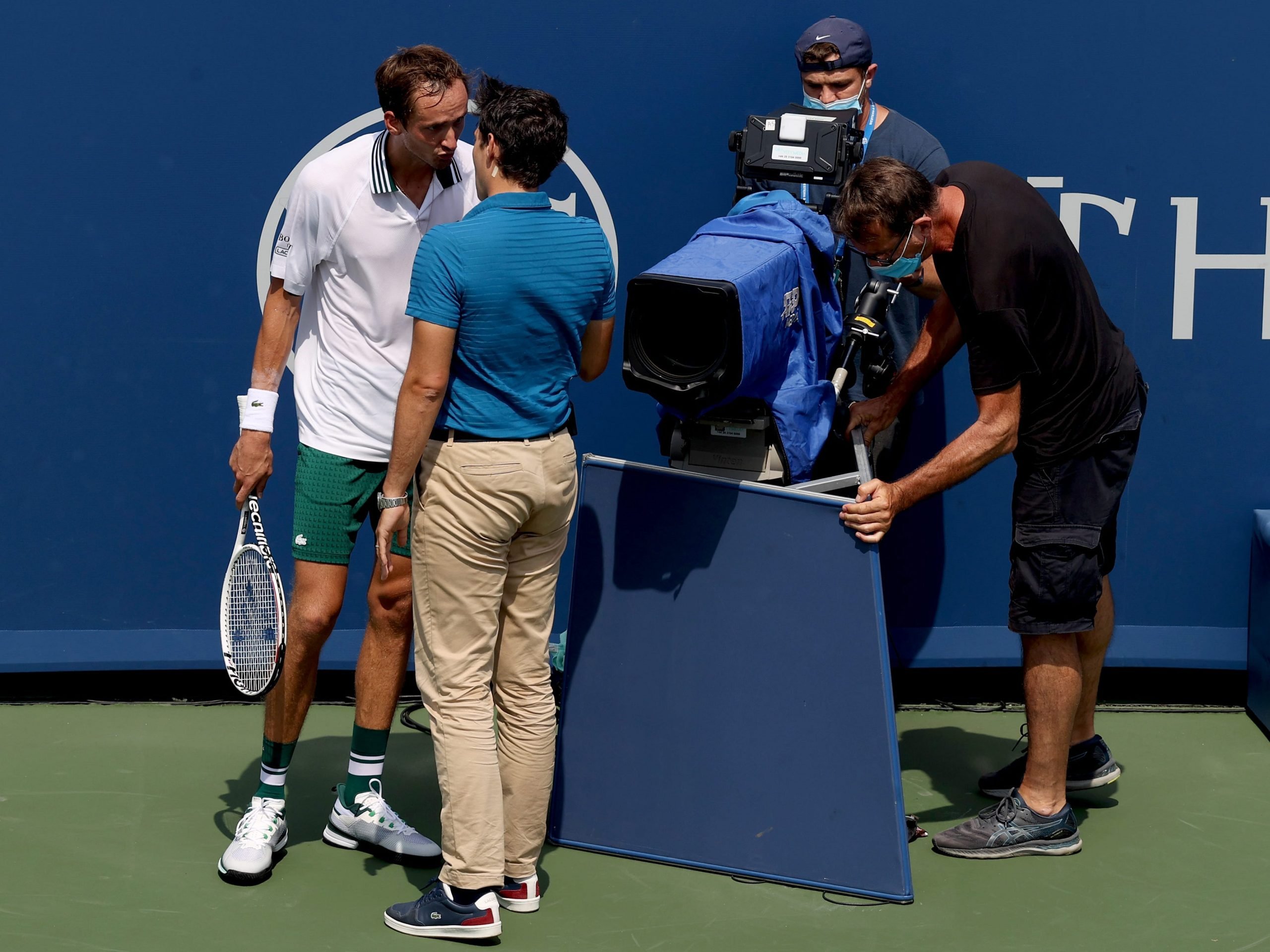 Daniil Medvedev speaks to chair umpire Nacho Forcadell after colliding with a television camera in his match against Andrey Rublev