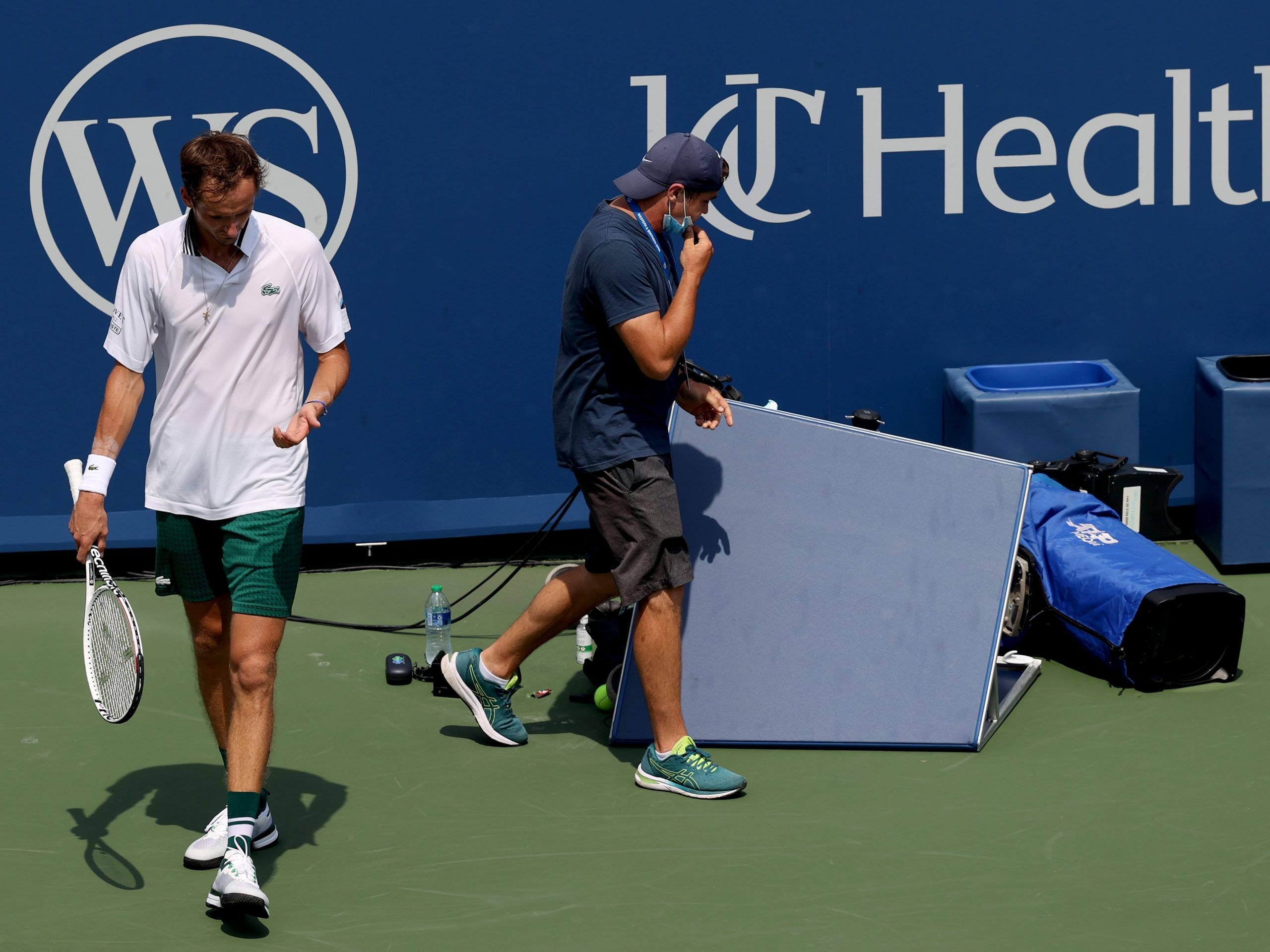 Daniil Medvedev examines his hand after colliding with a television camera