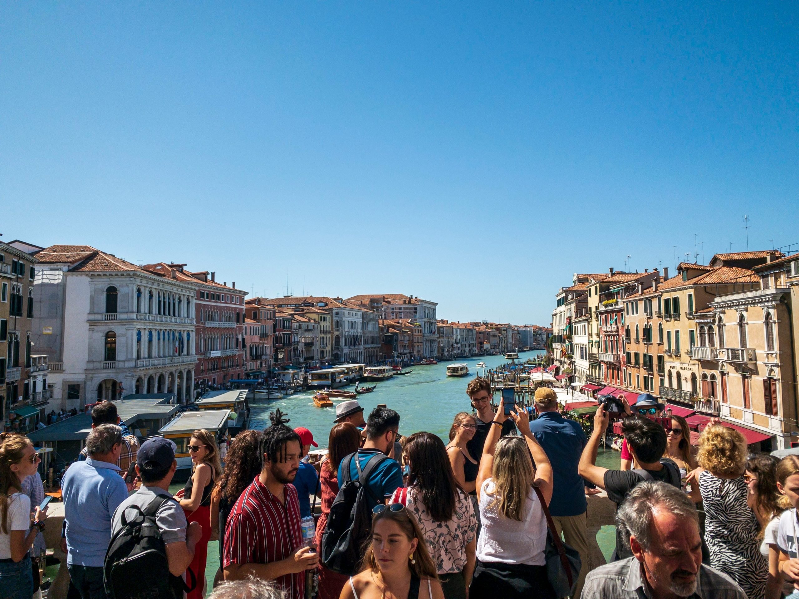 Rialto Bridge overlooking Grand Canal with crowds of tourist, Venice, Italy