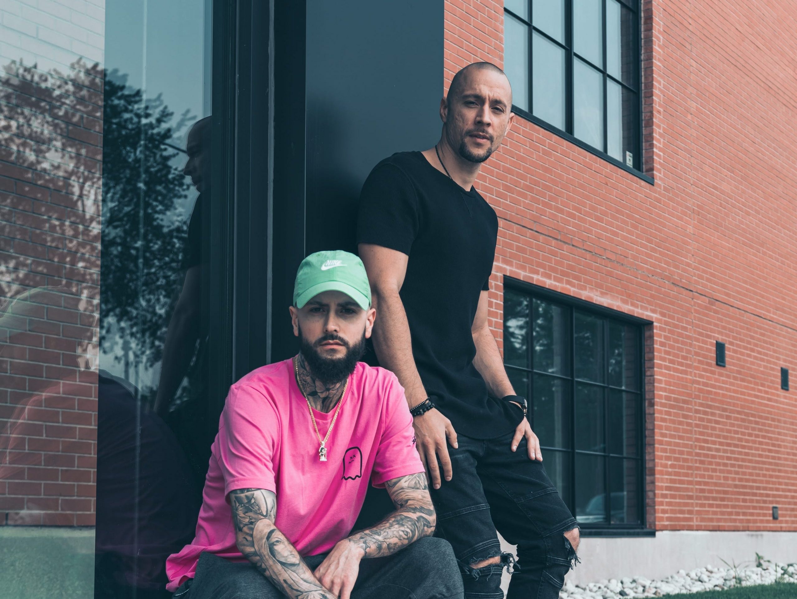 Dan Shaba and John Nonny pose together outside of a building.