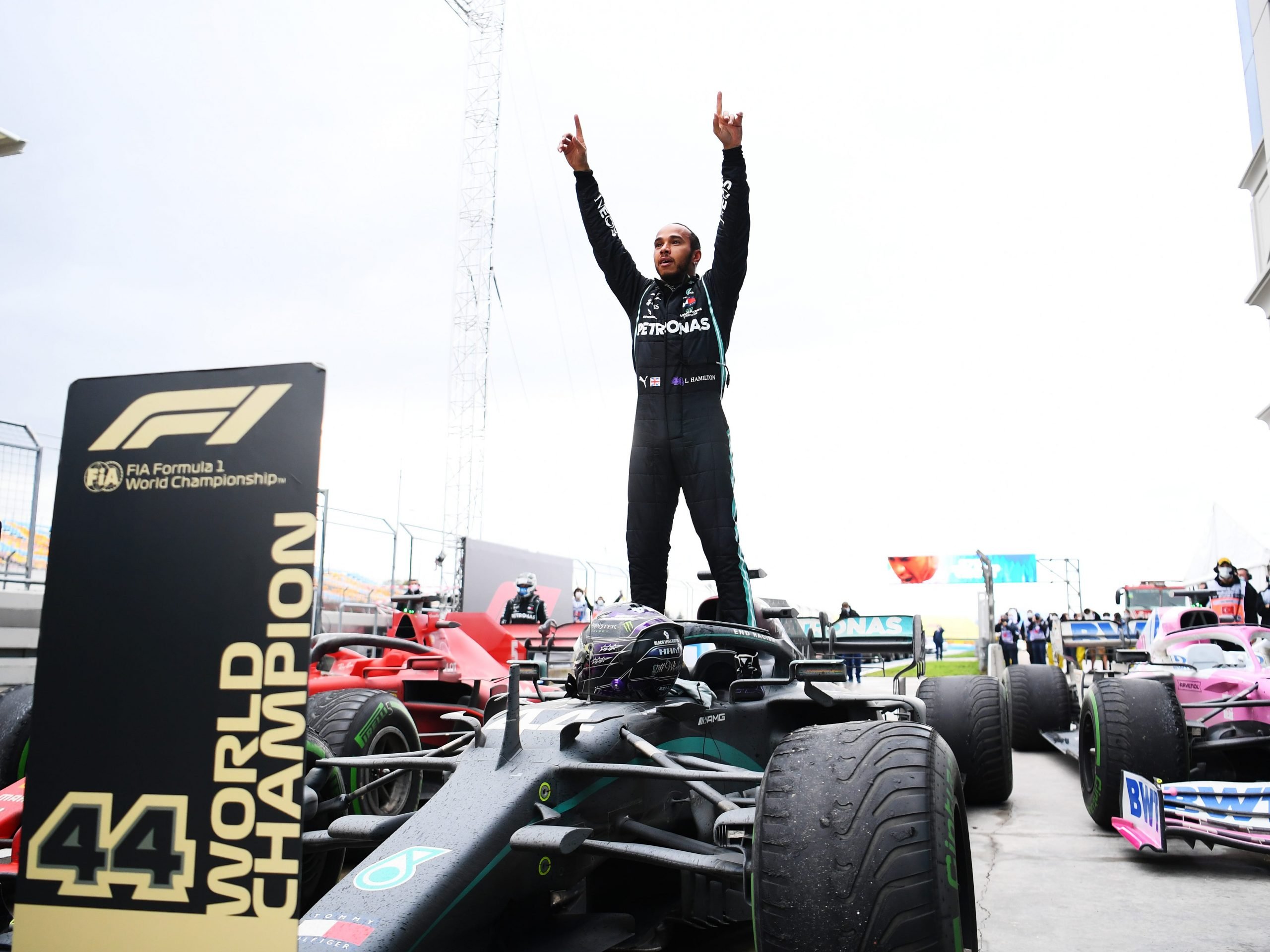 Lewis Hamilton stands on top of his car and celebrates