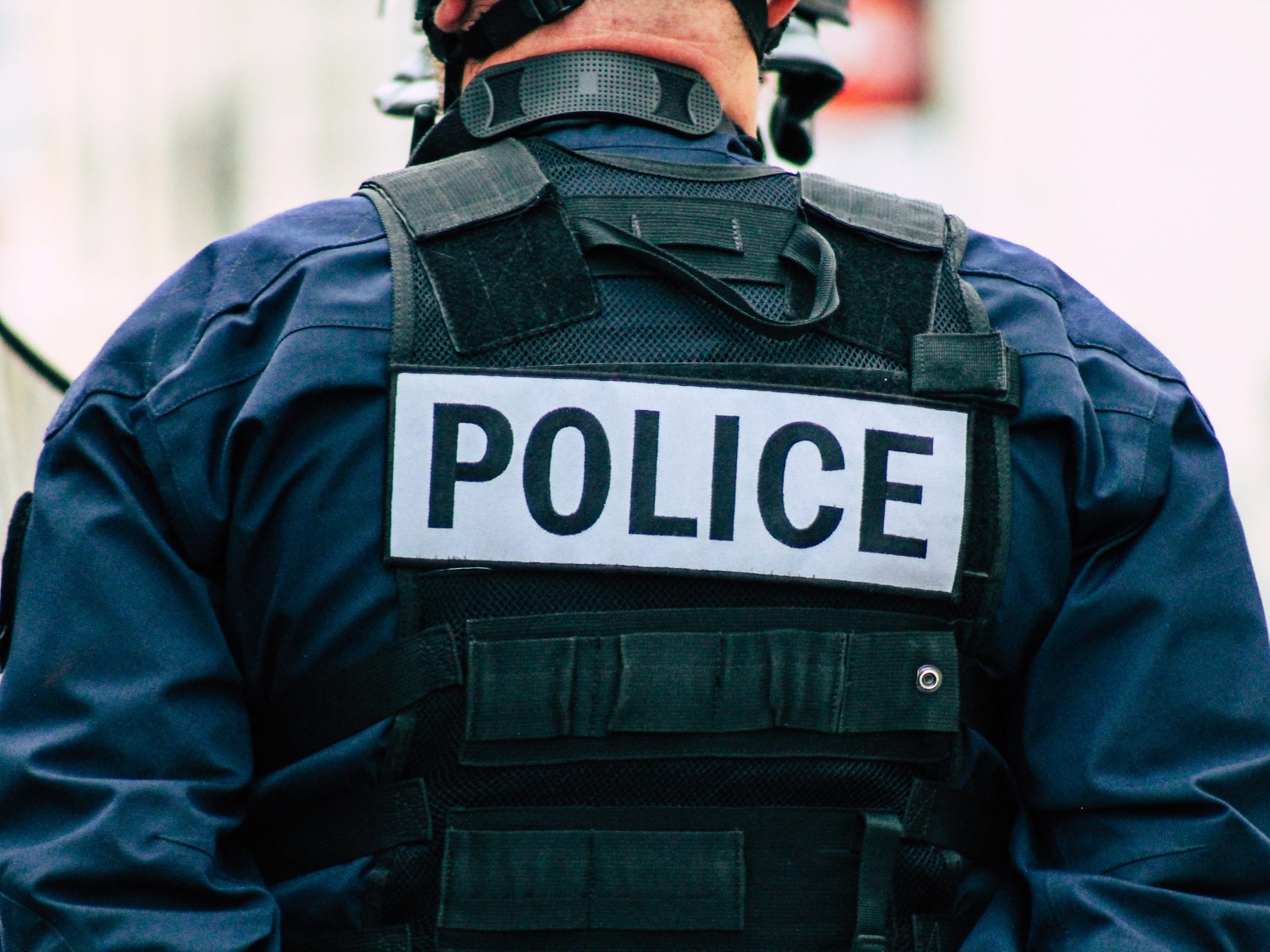 A police officer stands with his back to the camera