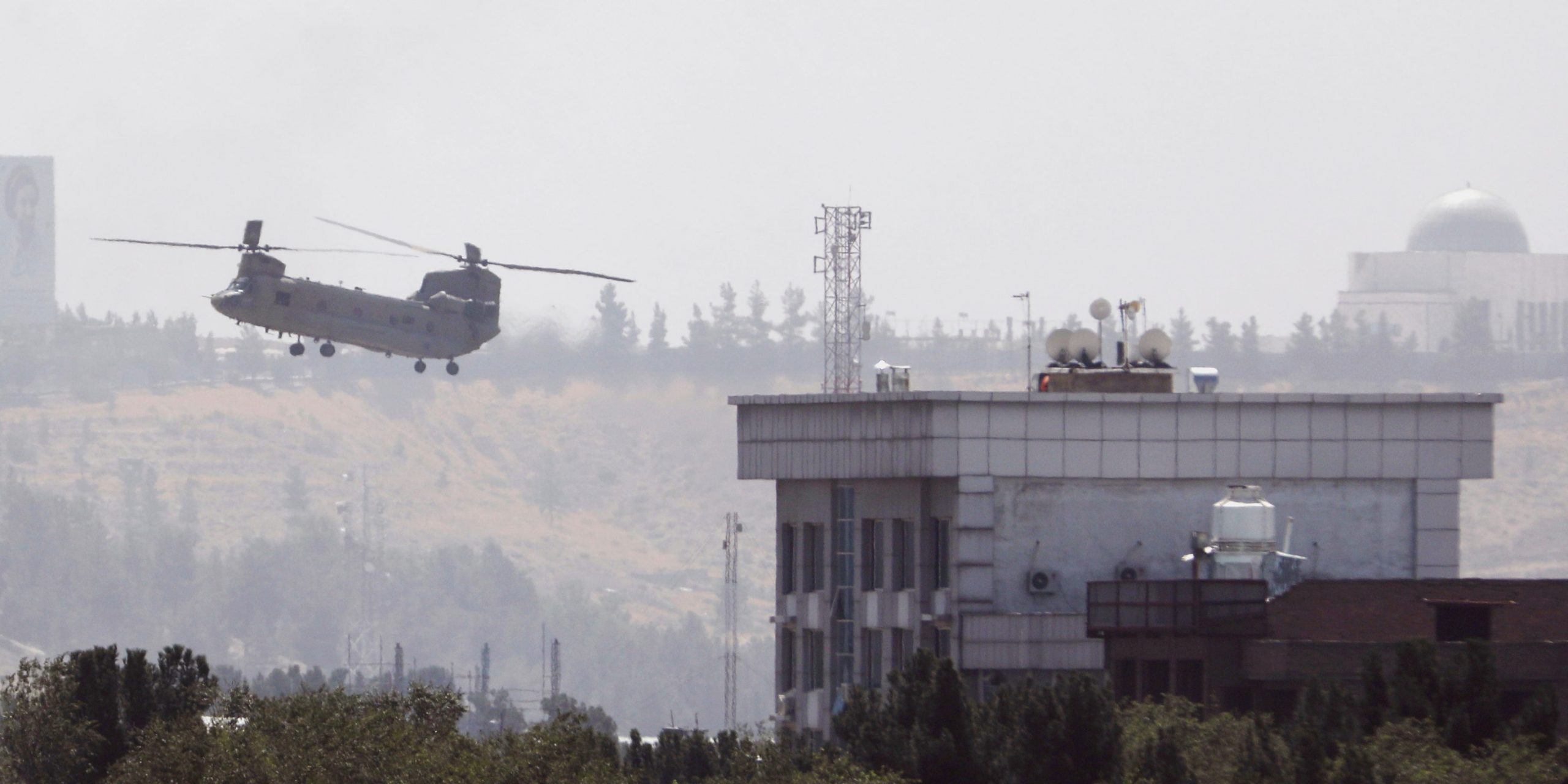 A U.S. Chinook helicopter flies near the U.S. Embassy in Kabul, Afghanistan, Sunday, Aug. 15, 2021. Helicopters are landing at the U.S. Embassy in Kabul as diplomatic vehicles leave the compound amid the Taliban advanced on the Afghan capital.