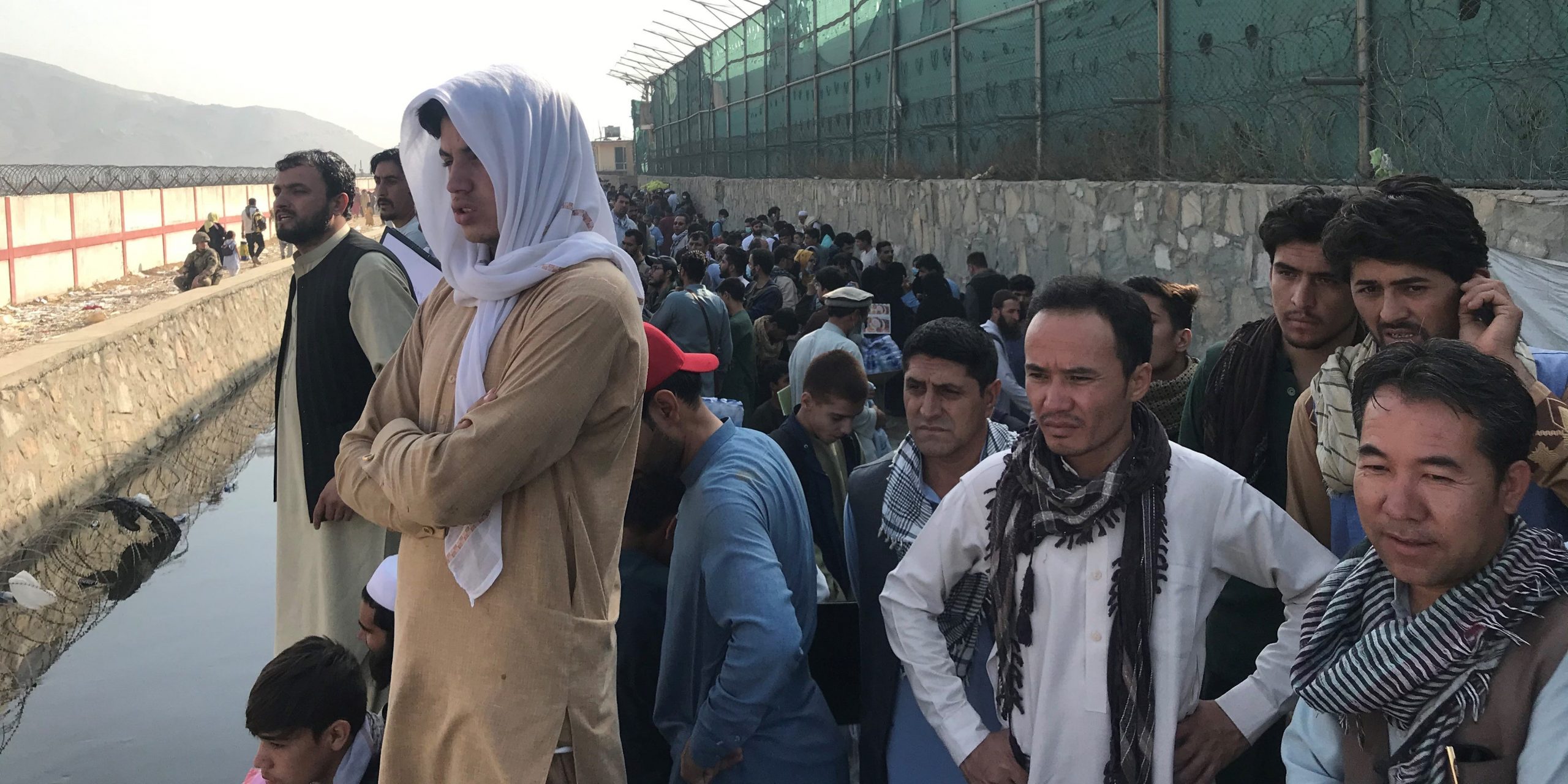 Afghans gather near a gate of Kabul airport