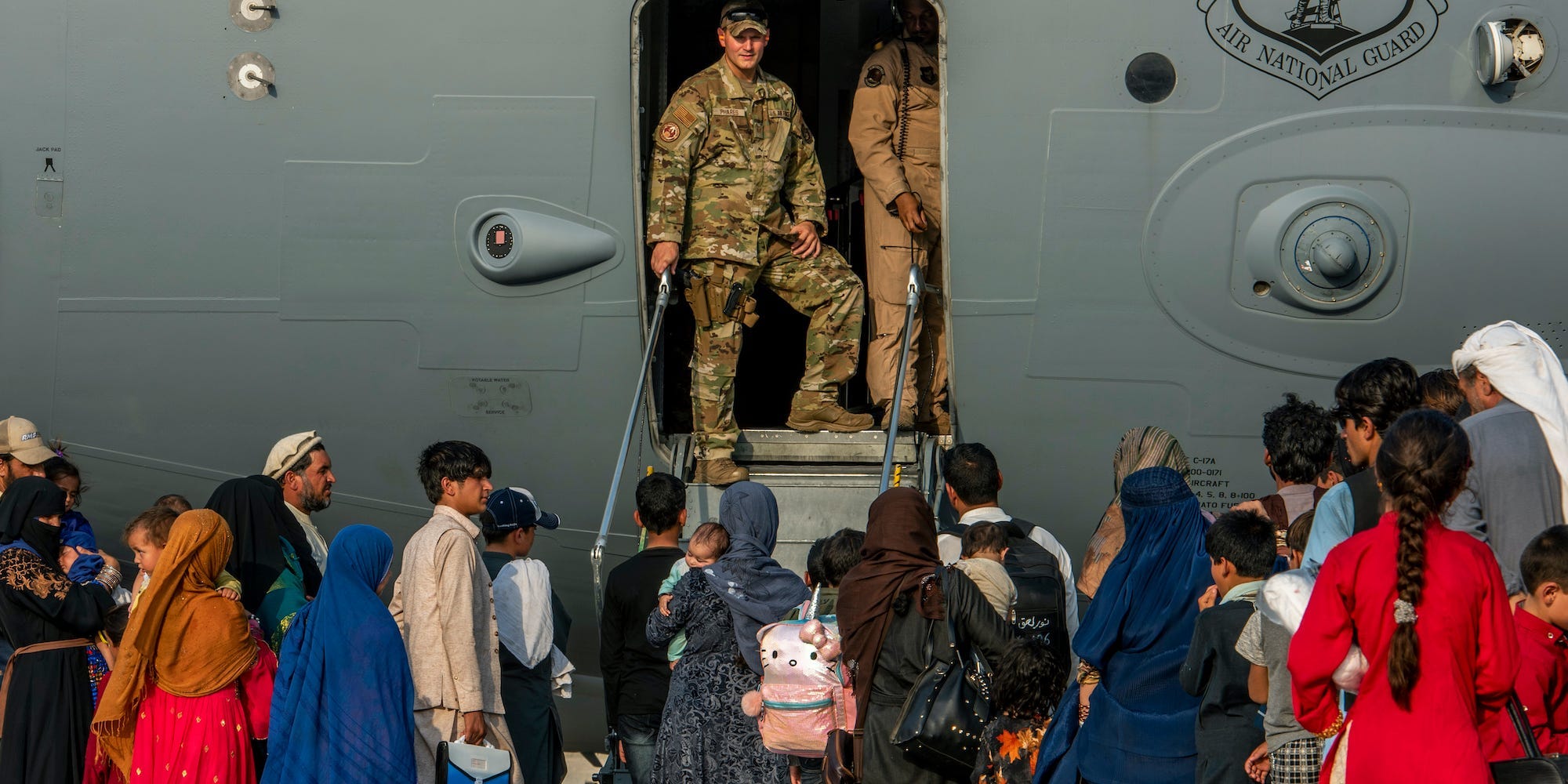 In this Aug. 22, 20121, image provided by the U.S. Air Force, service members prepare to board evacuees onto a C-17 Globemaster lll on Sunday, Aug. 22, 2021, at Al Udeid Air Base, Qatar.