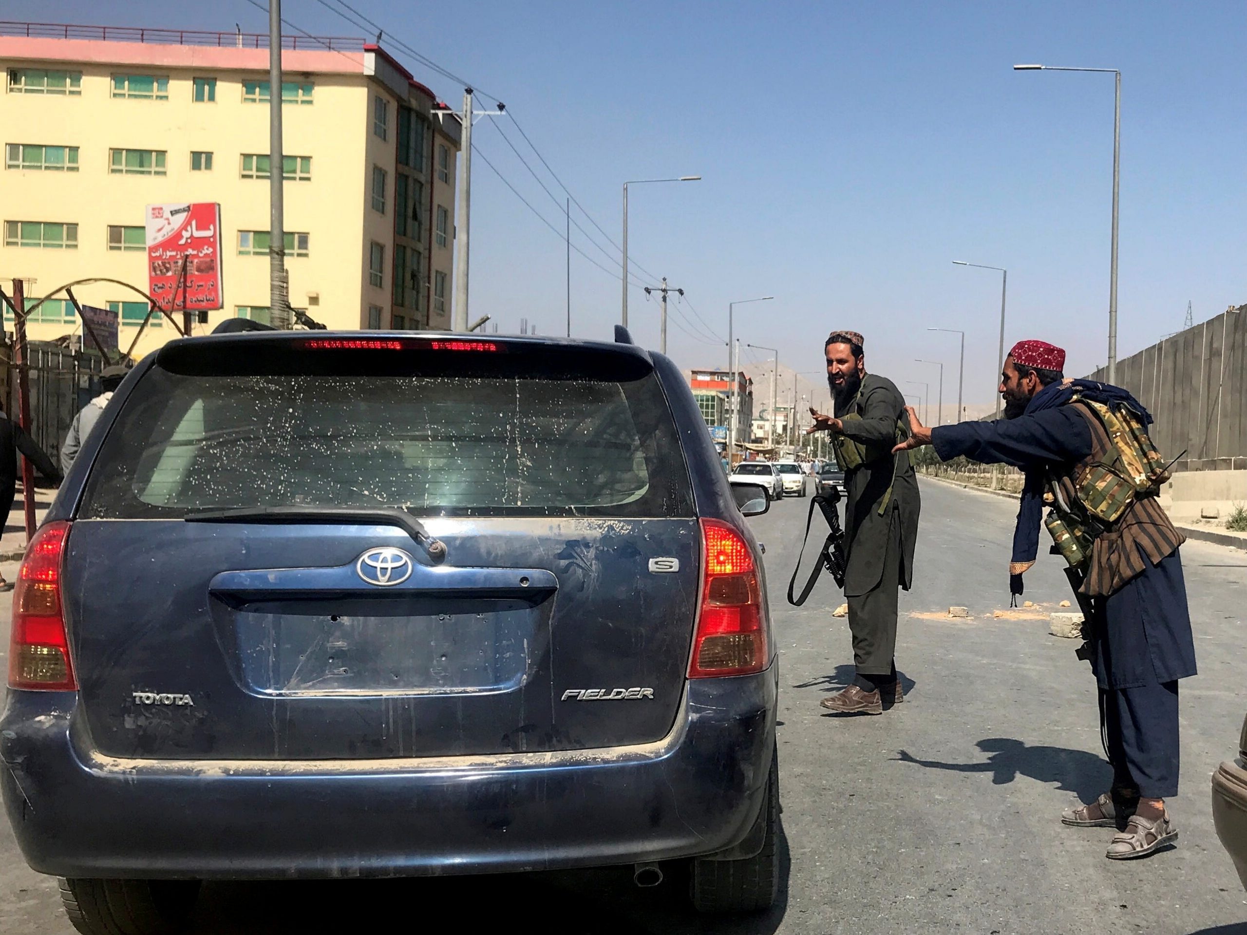 FILE PHOTO: Members of Taliban forces gesture as they check a vehicle on a street in Kabul, Afghanistan, August 16, 2021.