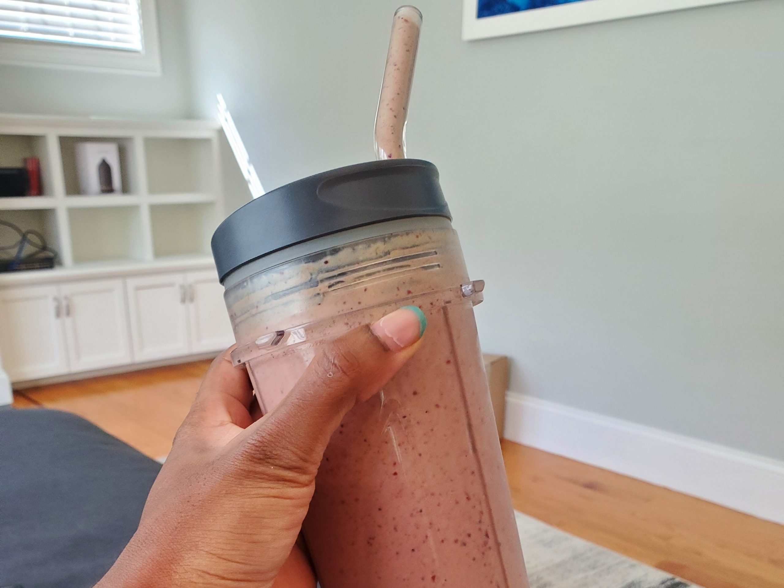 hand holding fruit smoothie