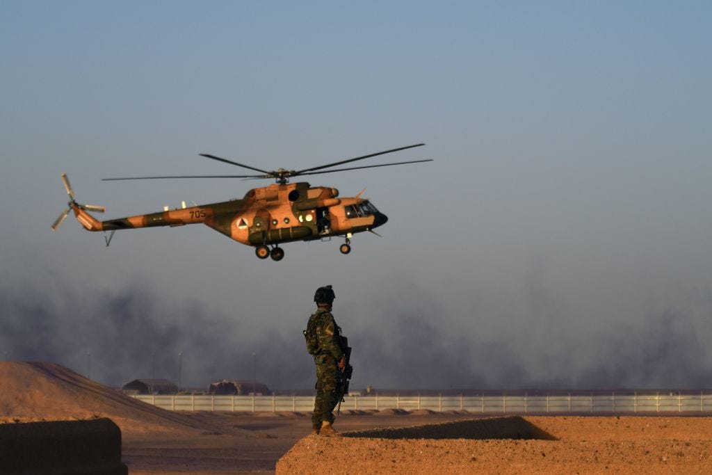 An Afghan Commandos stands guard while an Afghan Air Force helicopter flies past during a combat training exercise at the Shorab Military Camp in Lashkar Gah in the Afghan province of Helmand
