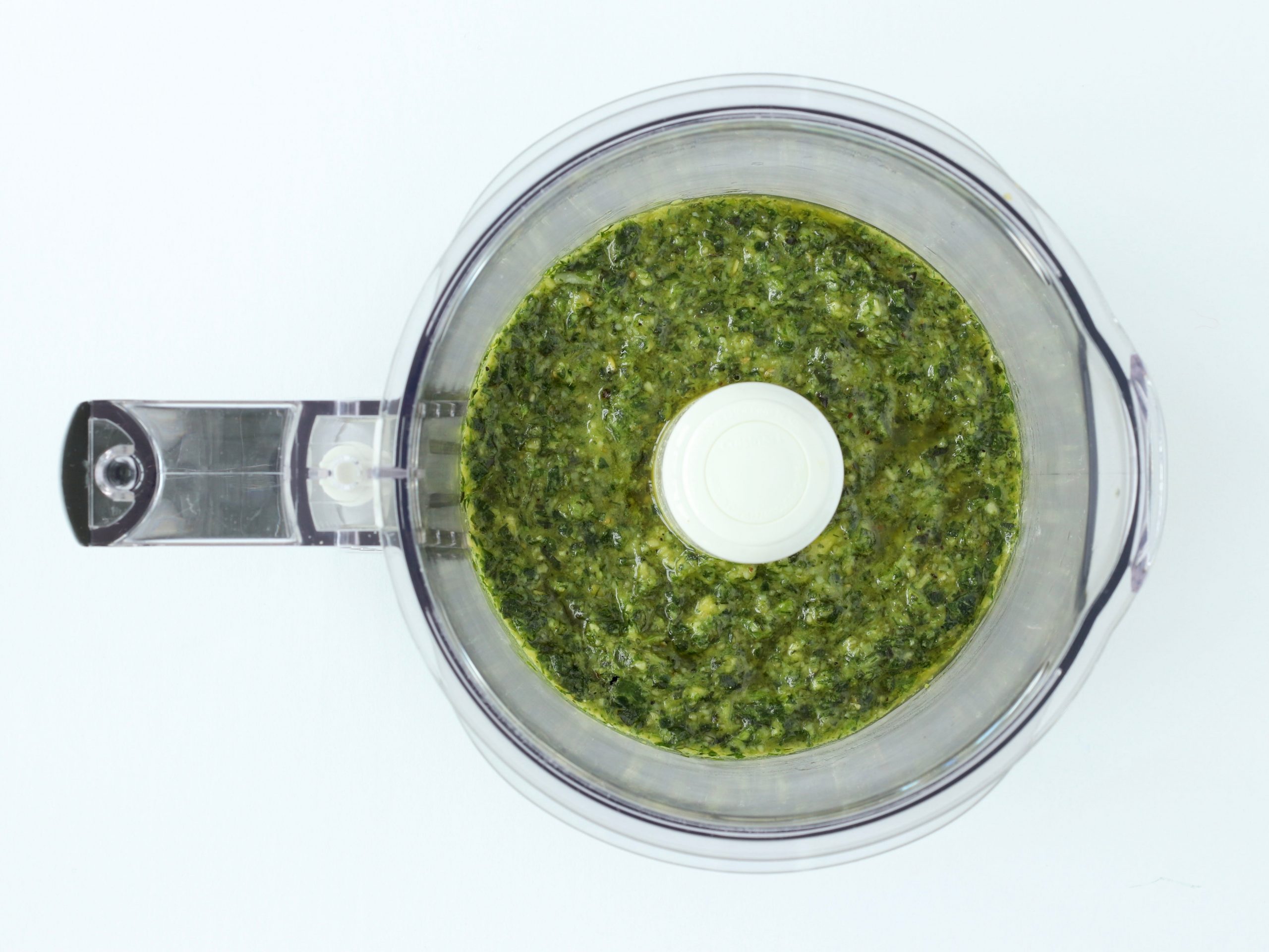 Pesto ingredients in a food processor.