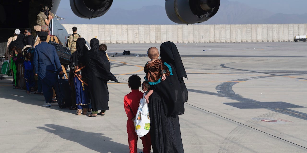 U.S. Air Force loadmasters and pilots assigned to the 816th Expeditionary Airlift Squadron, load people being evacuated from Afghanistan onto a U.S. Air Force C-17 Globemaster III at Hamid Karzai International Airport in Kabul, Afghanistan, Tuesday, Aug. 24, 2021.