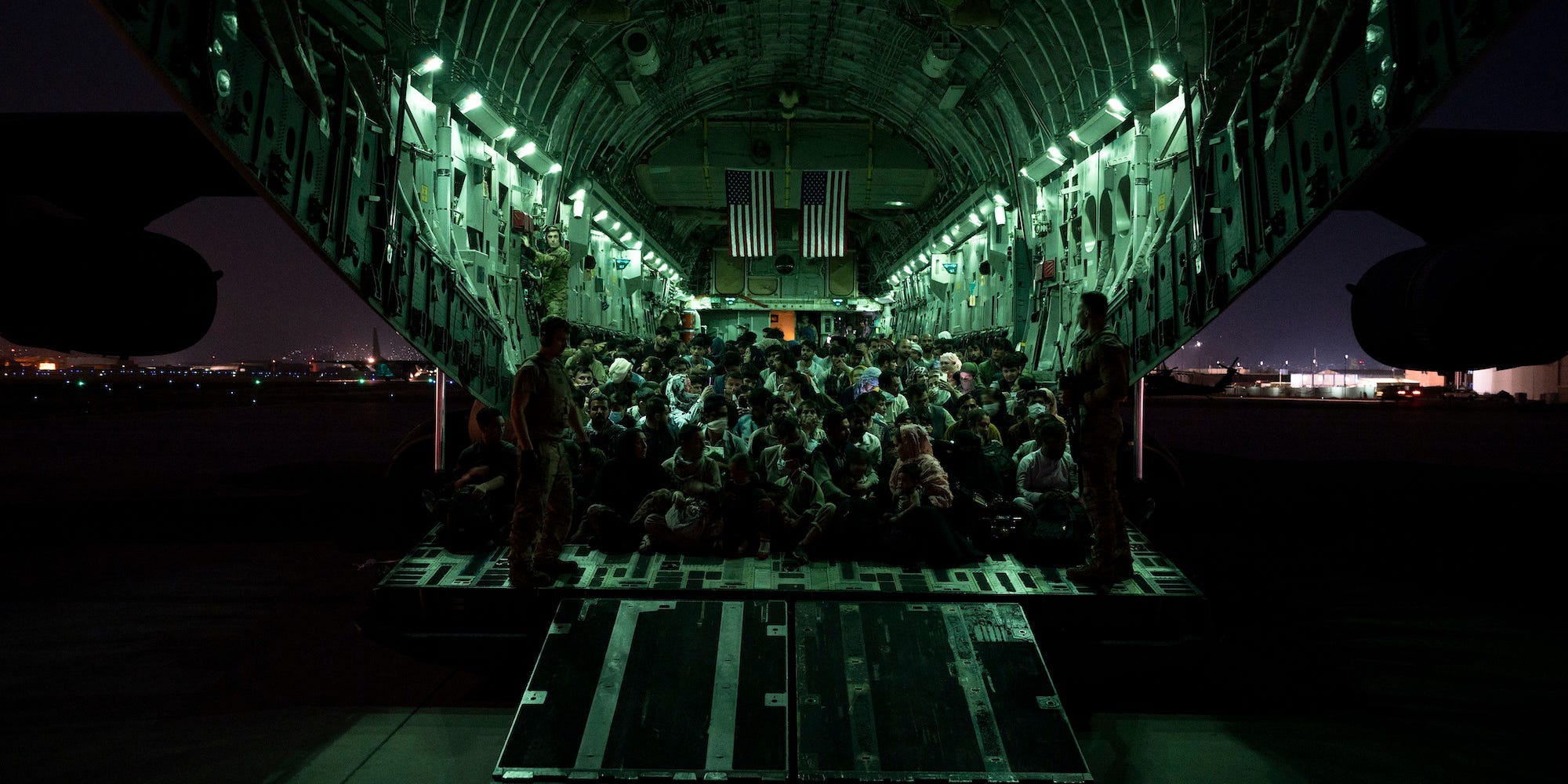 Evacuees on a military cargo plane at night