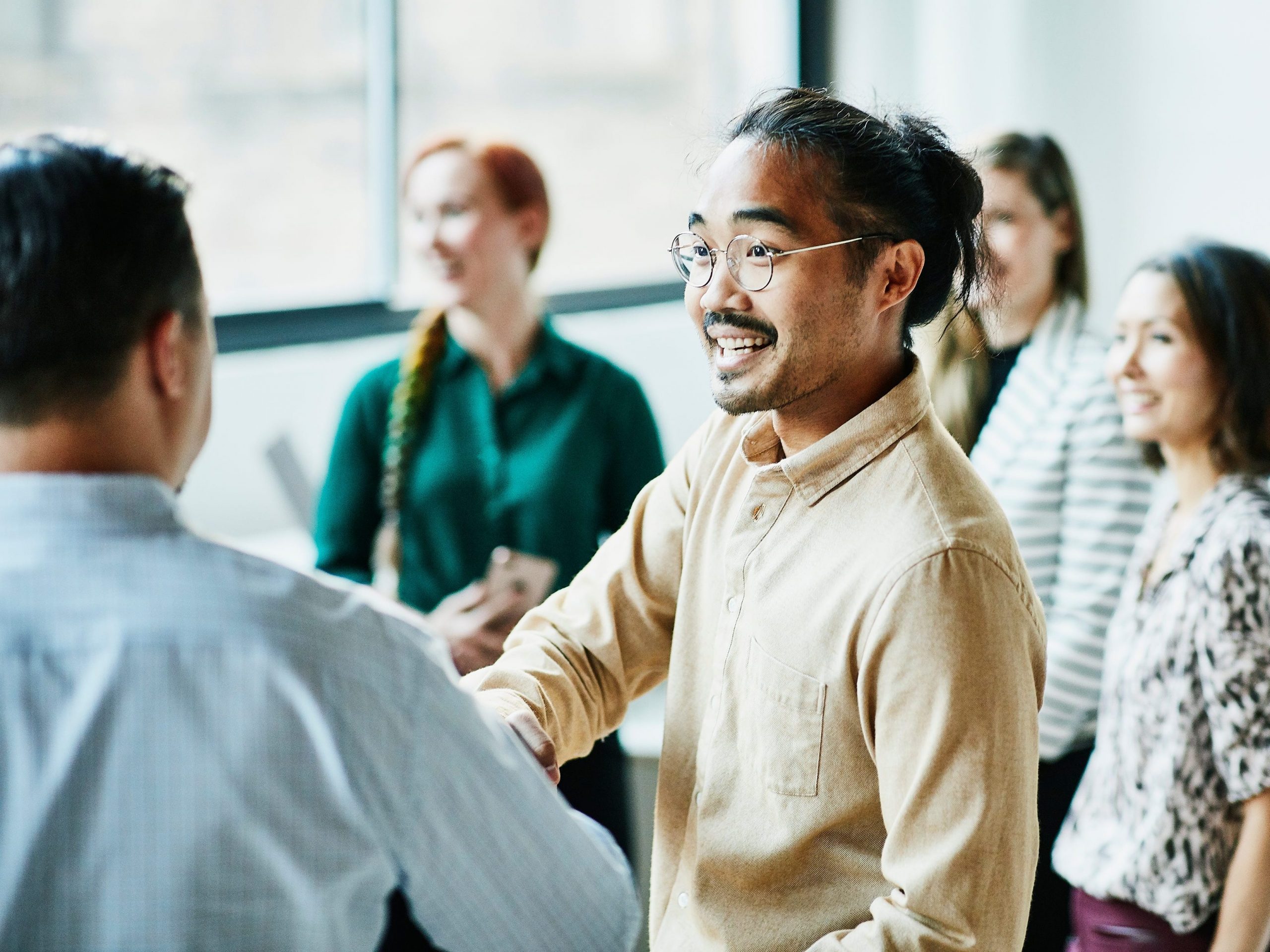 Businessman shaking hands with colleague after meeting in office coworkers networking