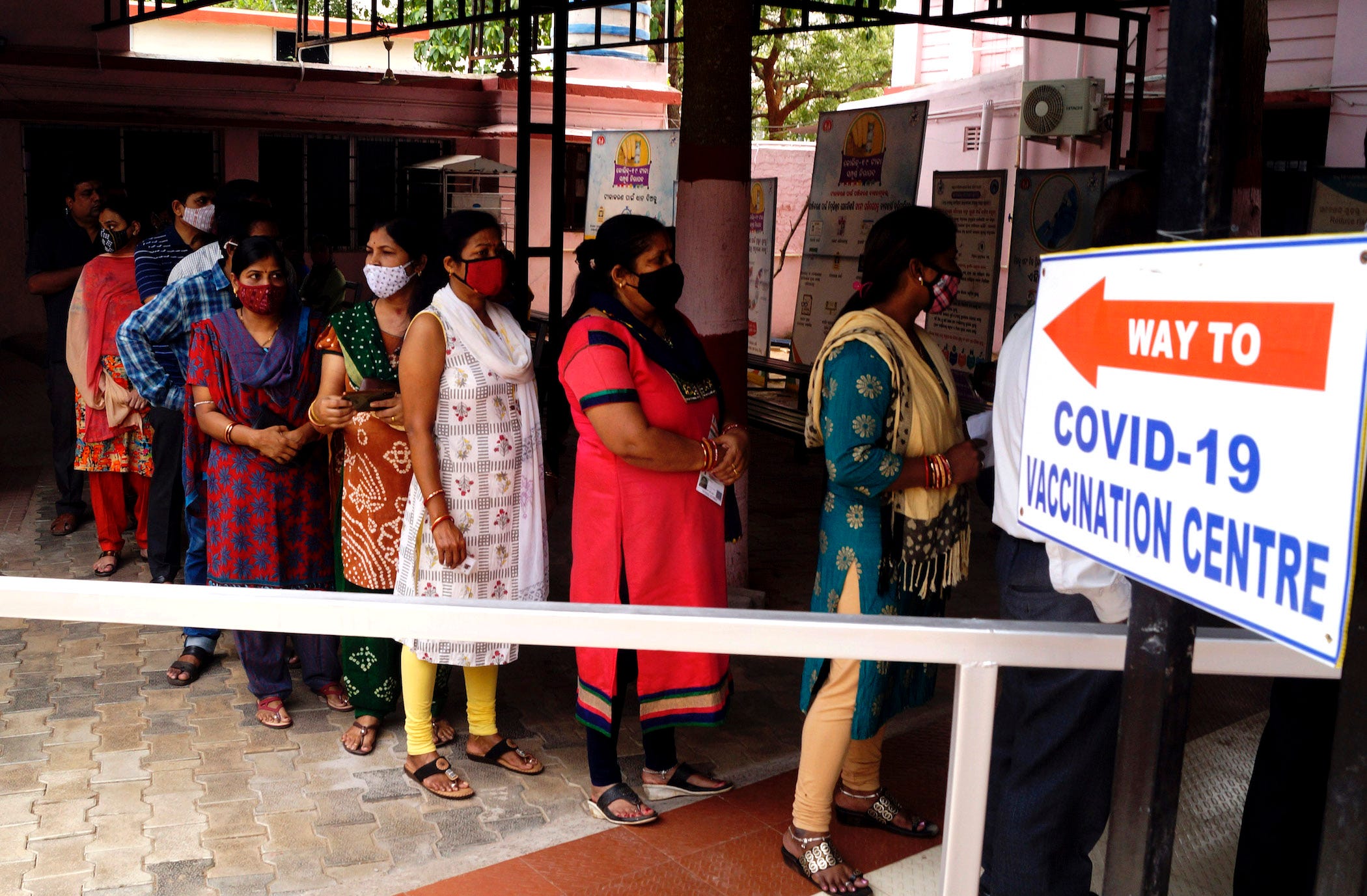 indian people in masks lining up to get vaccinated