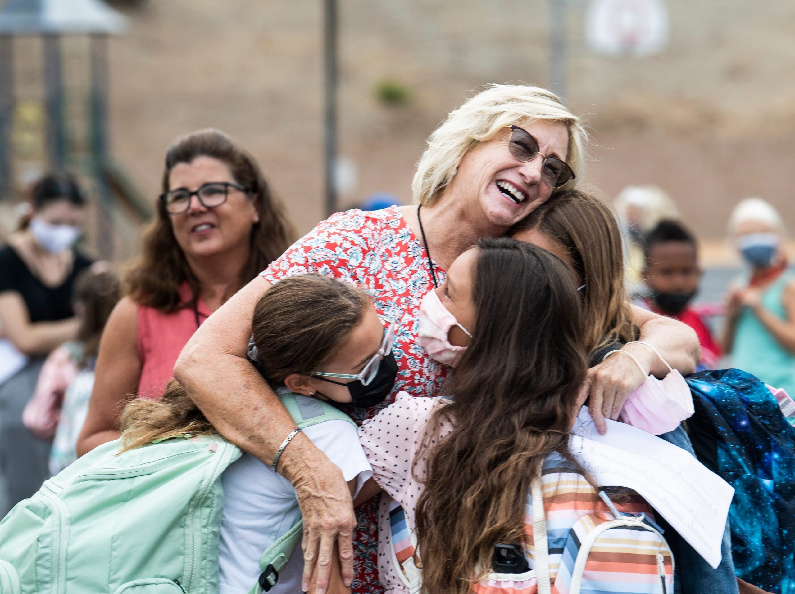 A teacher hugs three of her students from last year during the first day of class at Laguna Niguel Elementary School in Laguna Niguel on Tuesday, August 17, 2021.