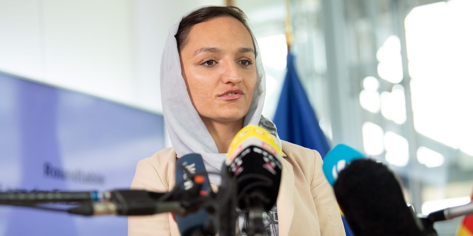 Zarifa Ghafari speaks in front of microphones