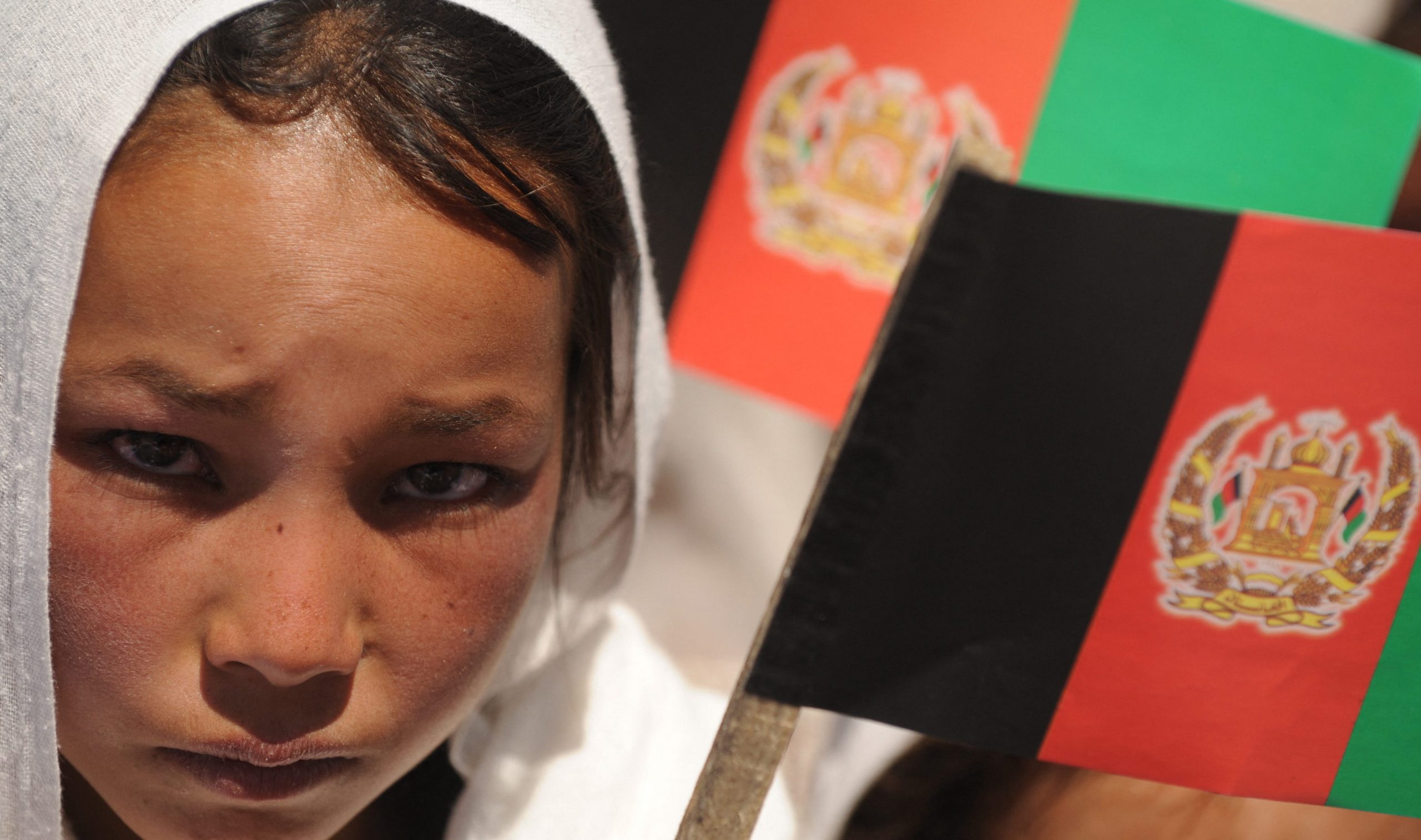 An Afghan ethnic Hazara girl holds a national flag at an event in 2009.