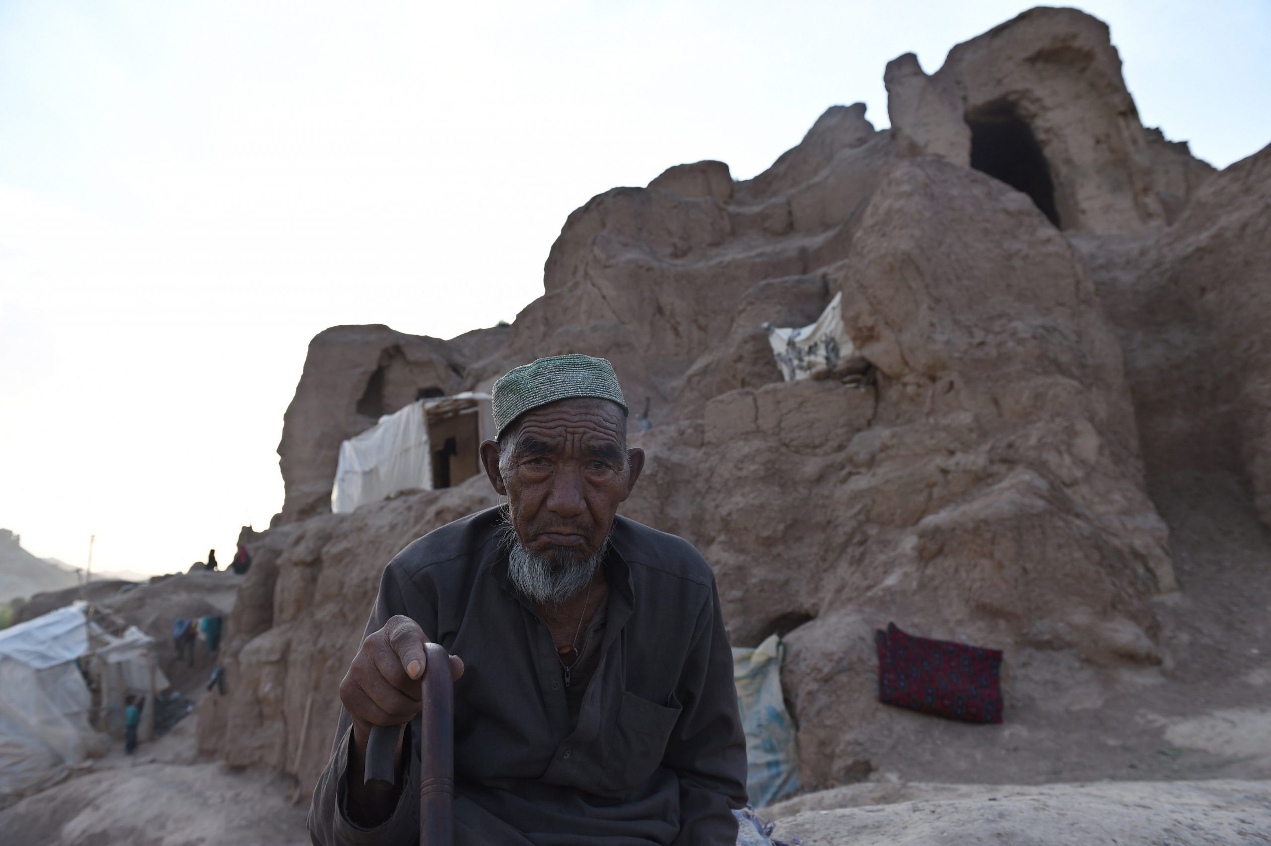 A Hazara Afghan man sits on the top of his cave in the old city of Bamiyan on June 19, 2015