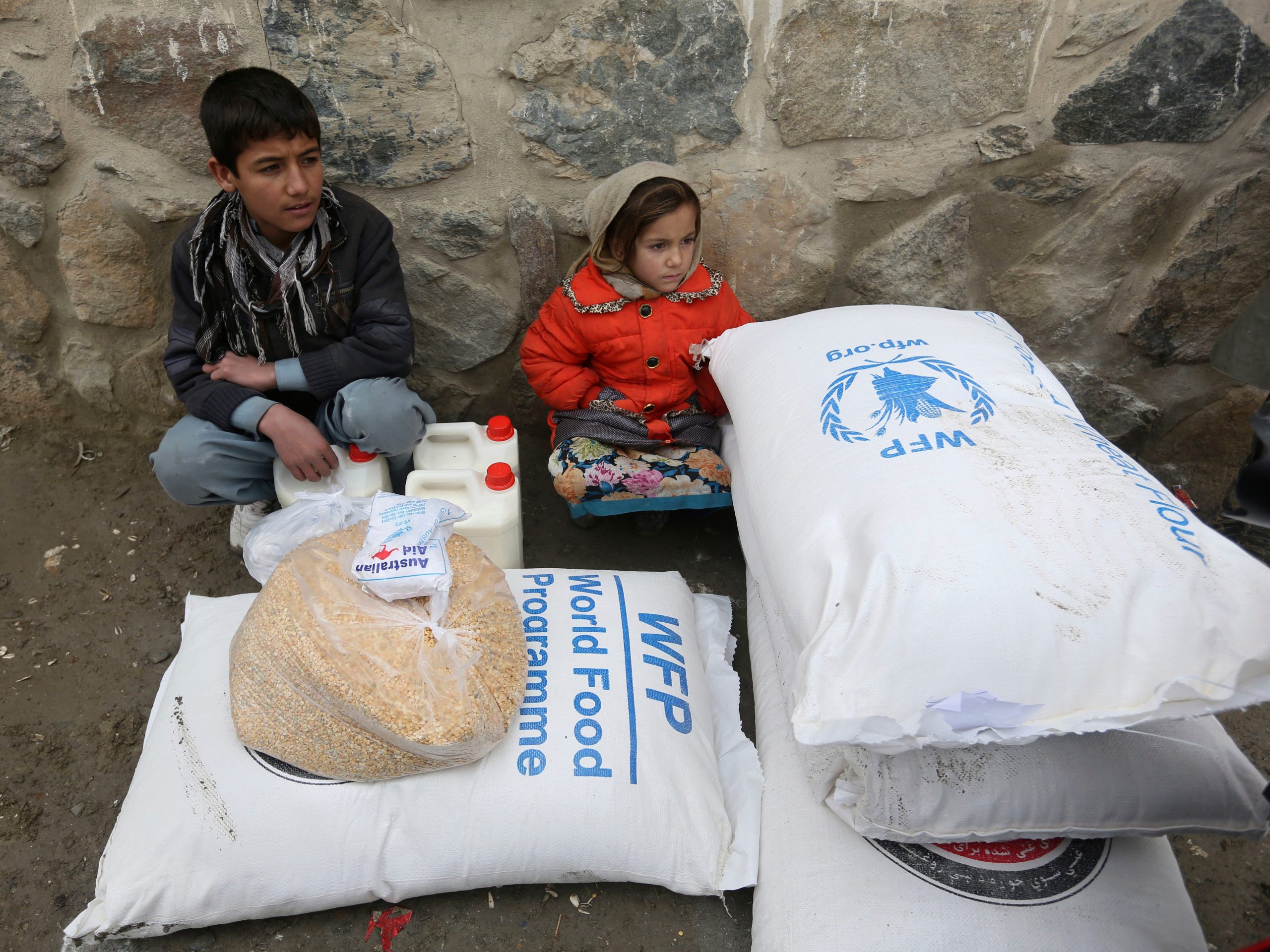 Children wait for transportation after receiving food donated by the World Food Program, in Kabul, Afghanistan, Tuesday, Jan. 24, 2017.