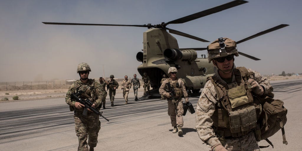US service members walk off a helicopter on the runway at Camp Bost on September 11, 2017 in Helmand Province, Afghanistan.