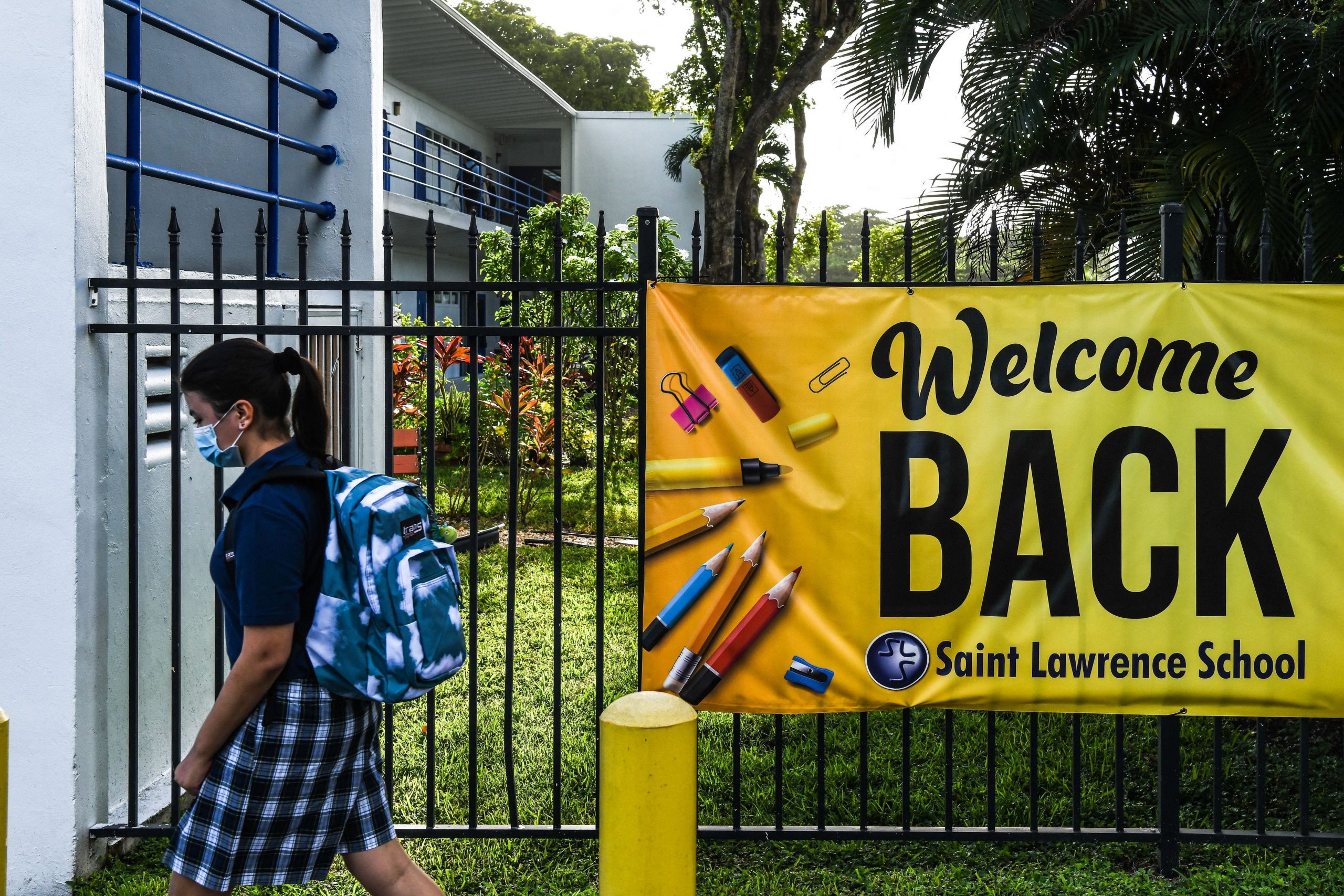 A student wears a mask as she enters the St. Lawrence Catholic School on the first day of school after summer vacation in north of Miami, on August 18, 2021.