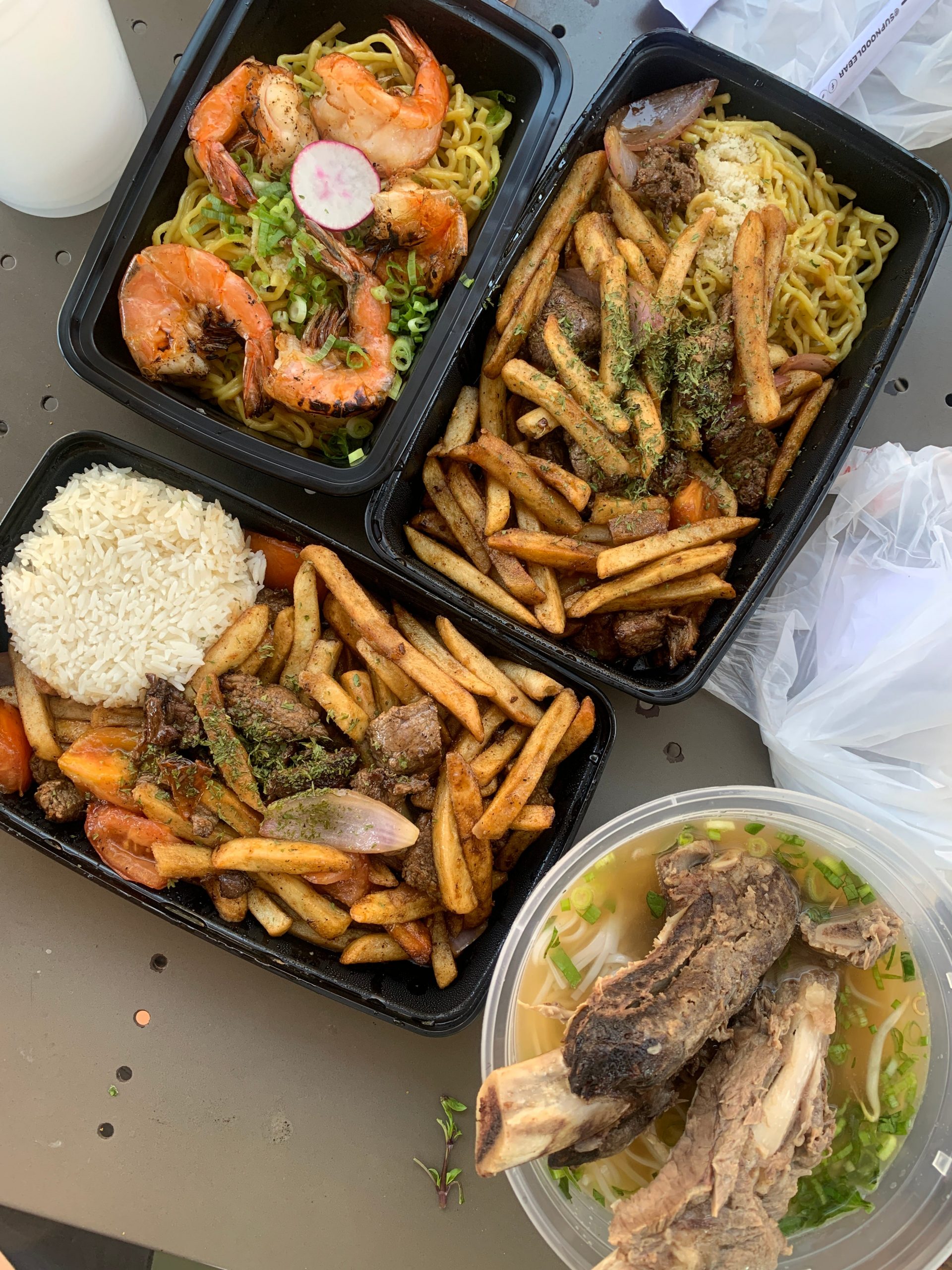 A few containers of food (shrimp, ribs, rice, fries).