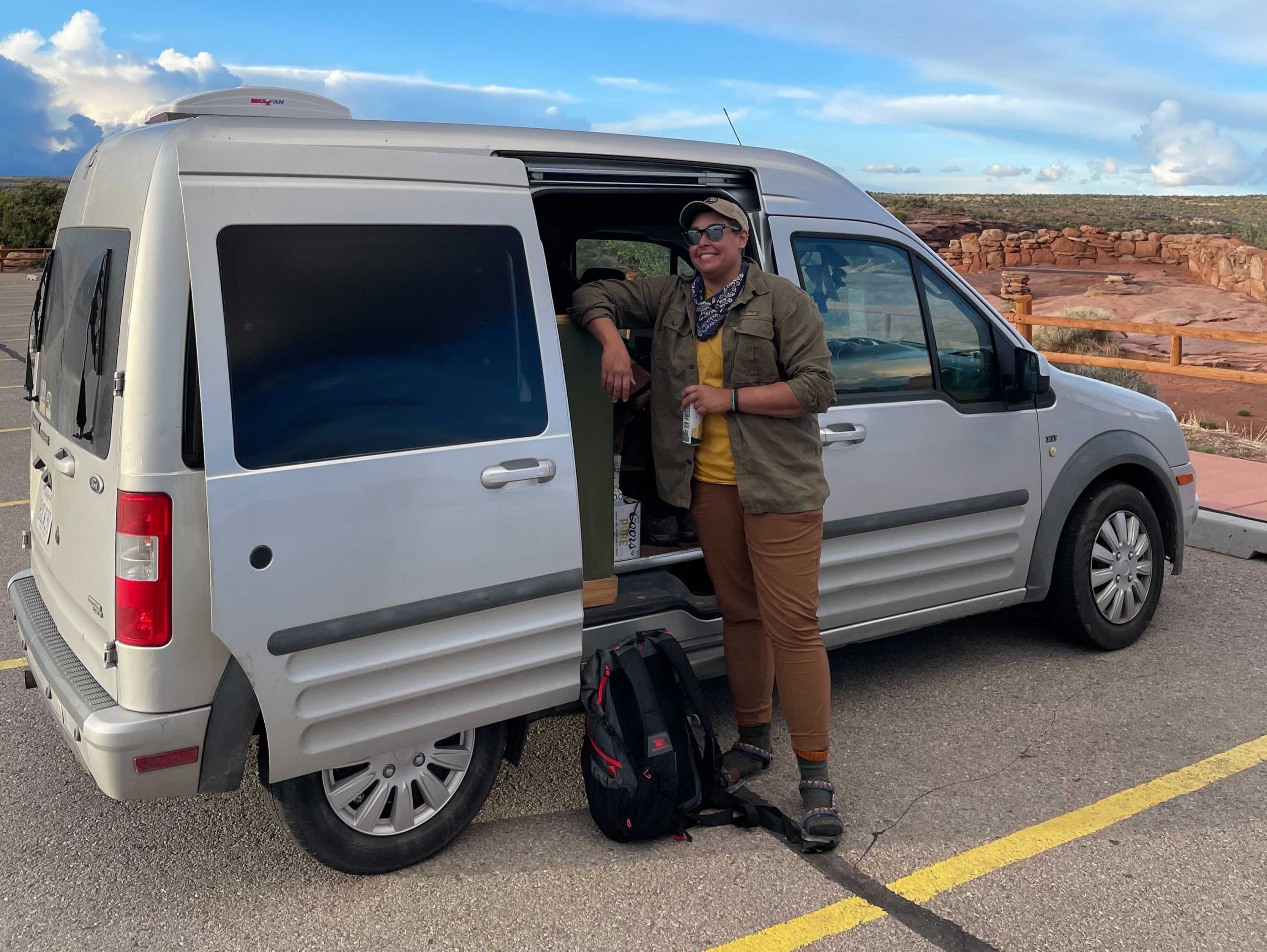 abbey standing next to converted van under a blue sky