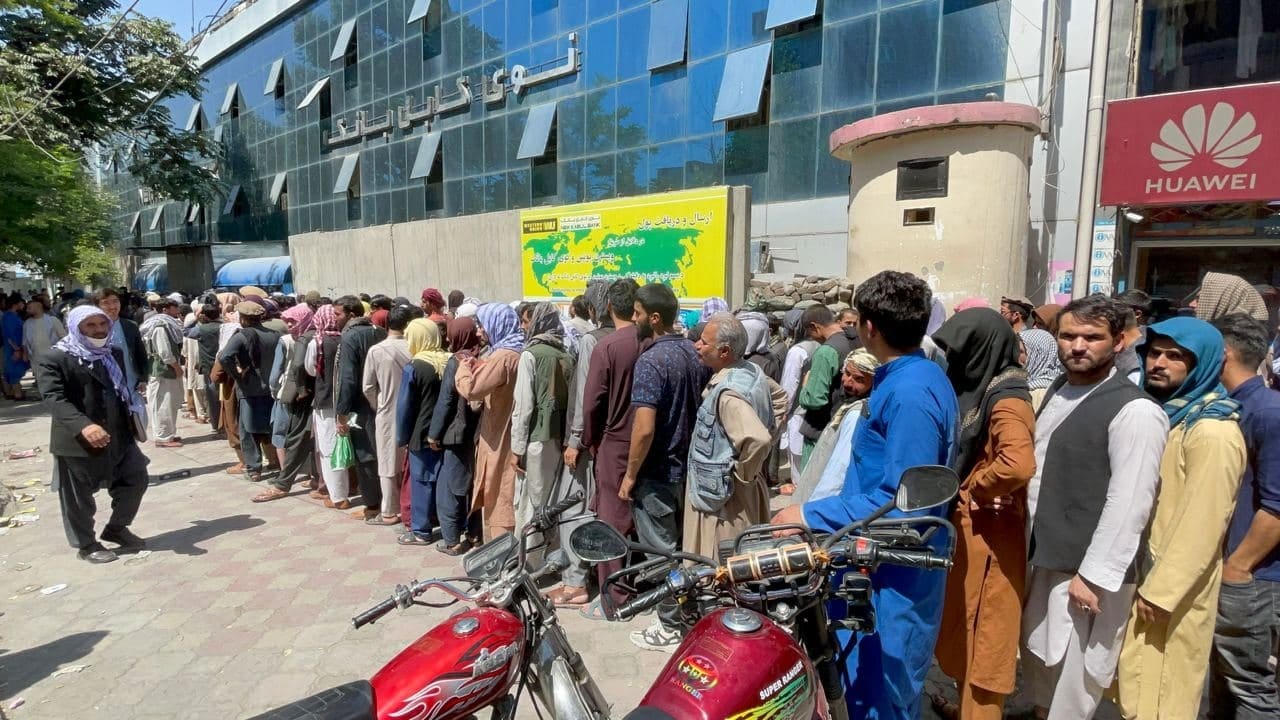 A long line of Afghans in the sun outside a bank in Kabul