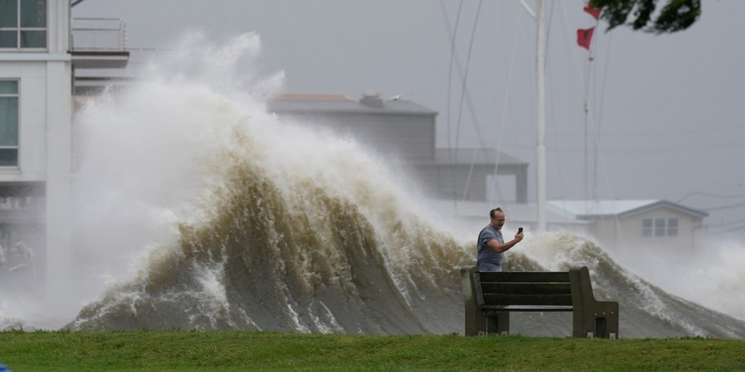 A man takes pictures of high waves along the shore of Lake Pontchartrain as Hurricane Ida nears, Sunday, Aug. 29, 2021, in New Orleans.