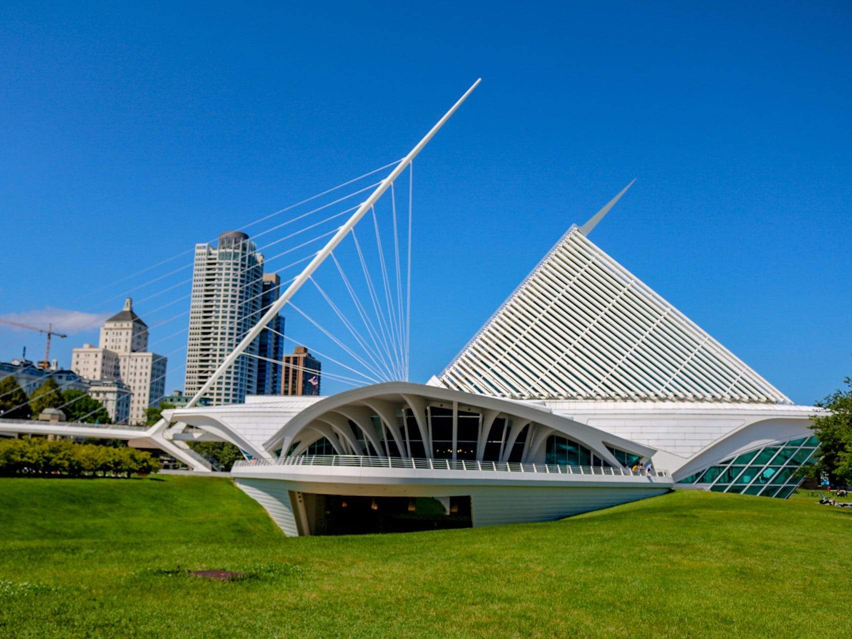 Outside of cool, white Milwaukee Art Museum building, with blue sky in the background