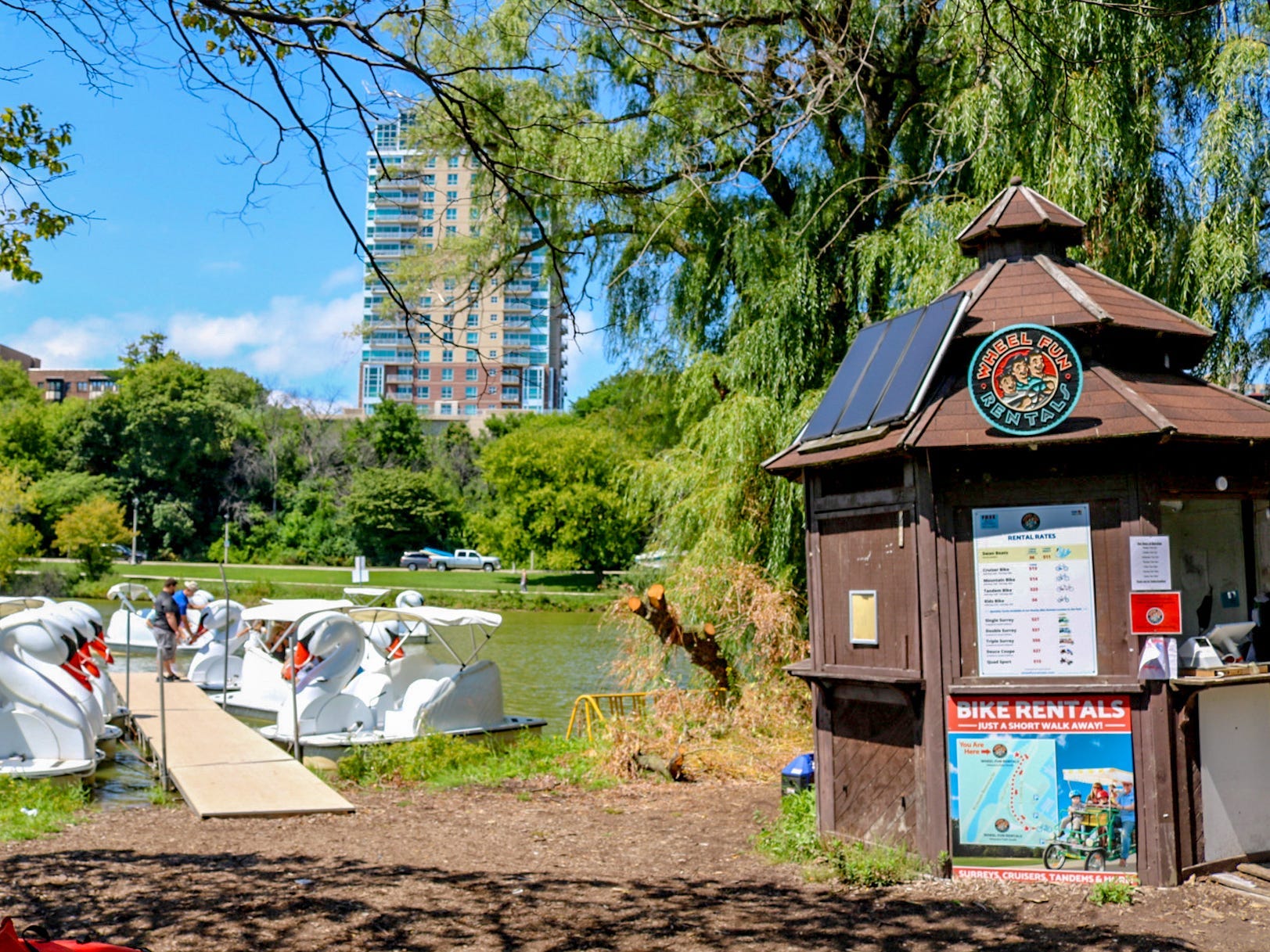 A view of veterans park, with boat, grass, and a building in the background