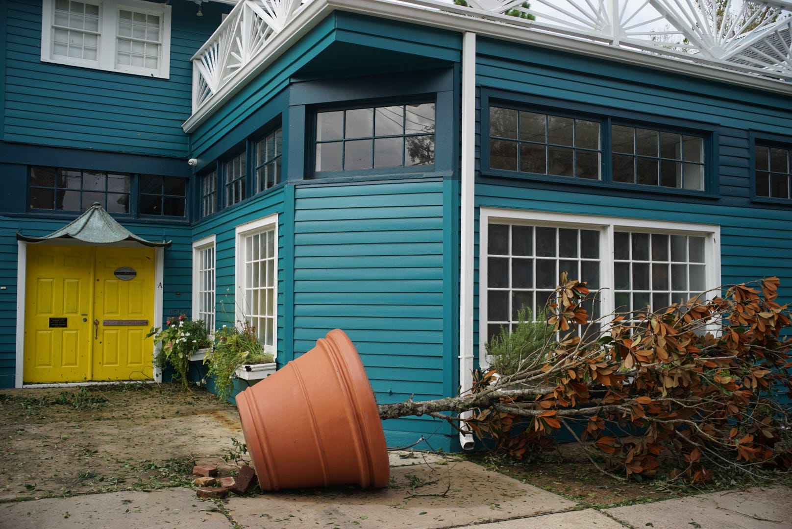 A large planter is seen on its side in front of a house