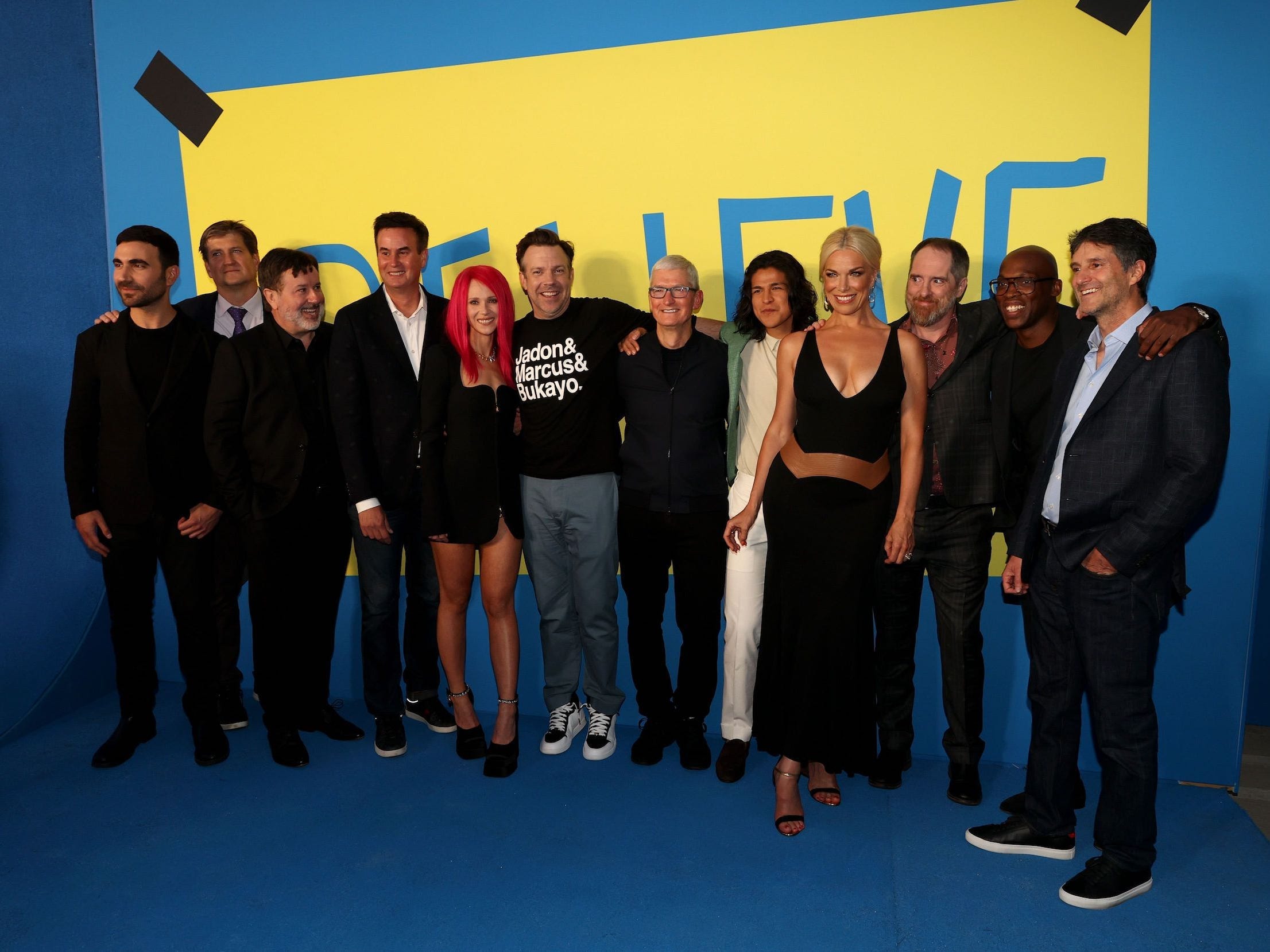 The cast of "Ted Lasso" at the show's premiere surrounds Apple CEO Tim Cook