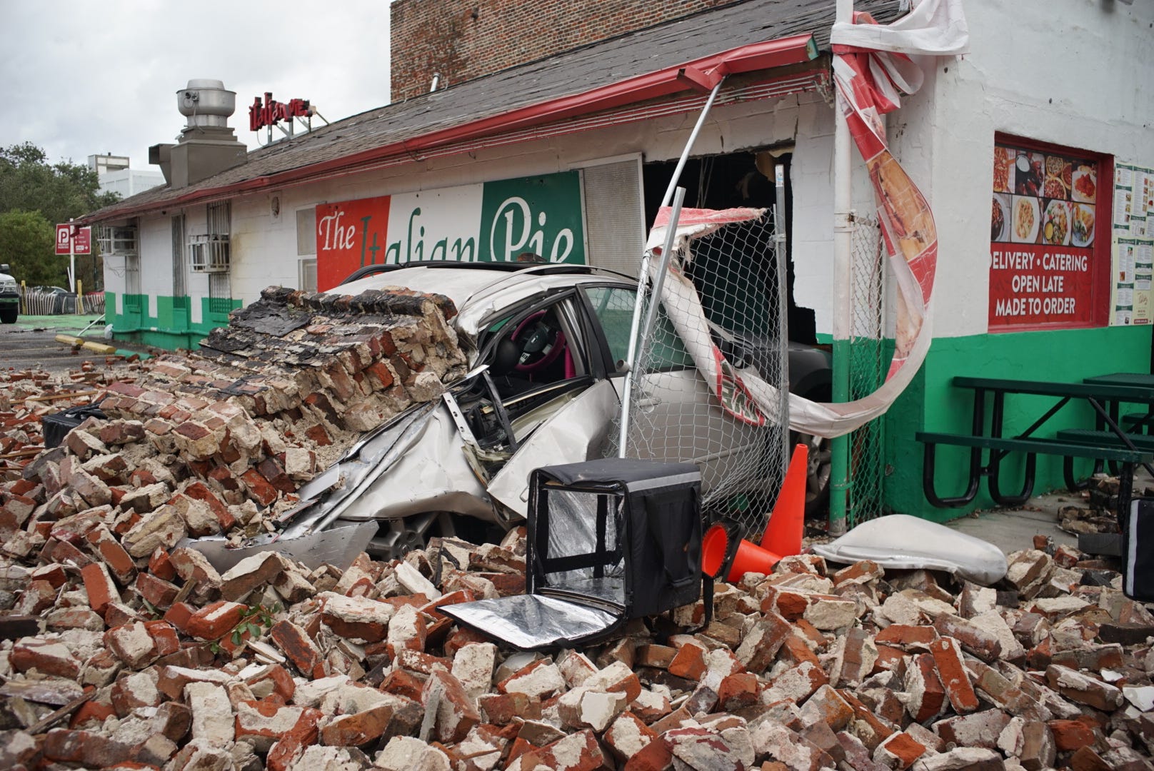 A car and a storefront are seen buried under debris