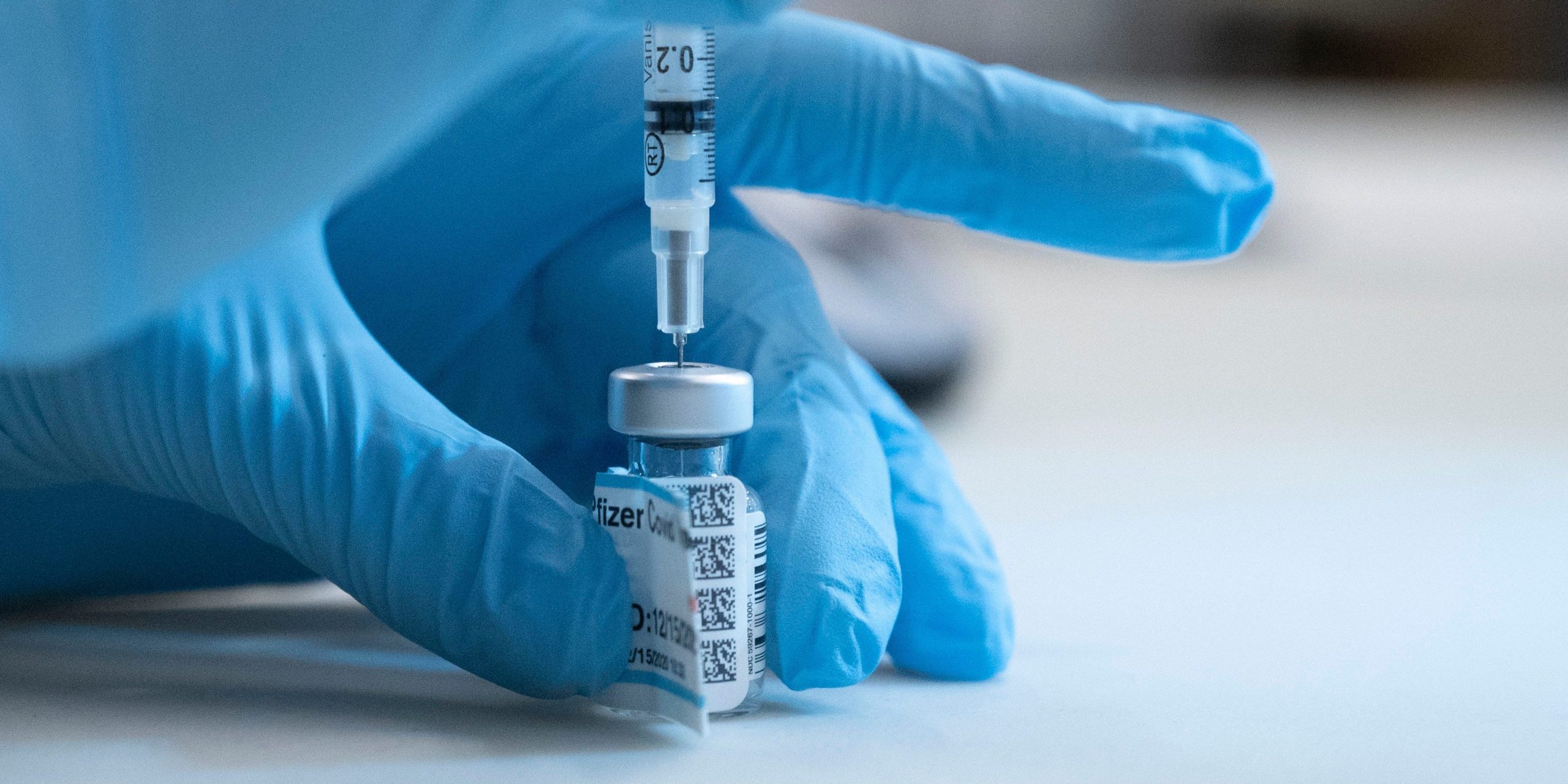 A nurse prepares to administer a COVID-19 vaccine.