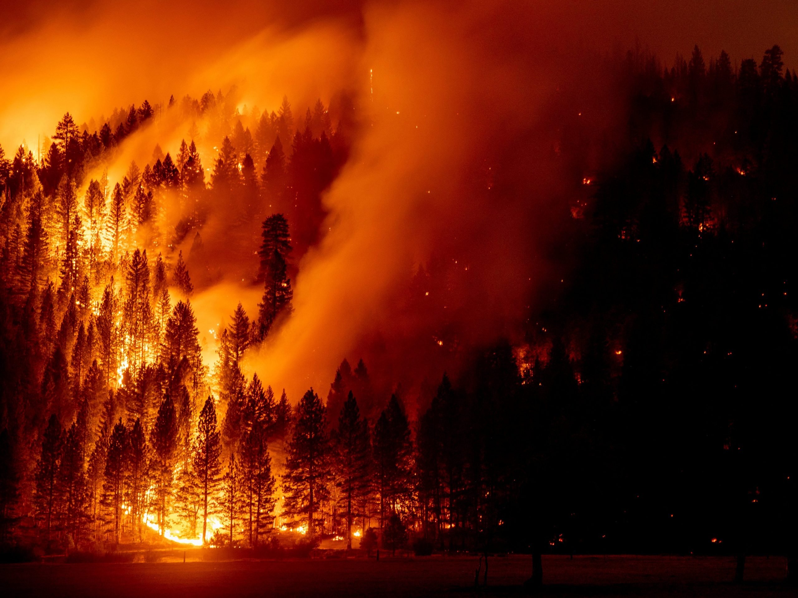 In this long exposure photo, flames from the Dixie Fire spread in Genesee, Calif., on Saturday, Aug. 21, 2021.