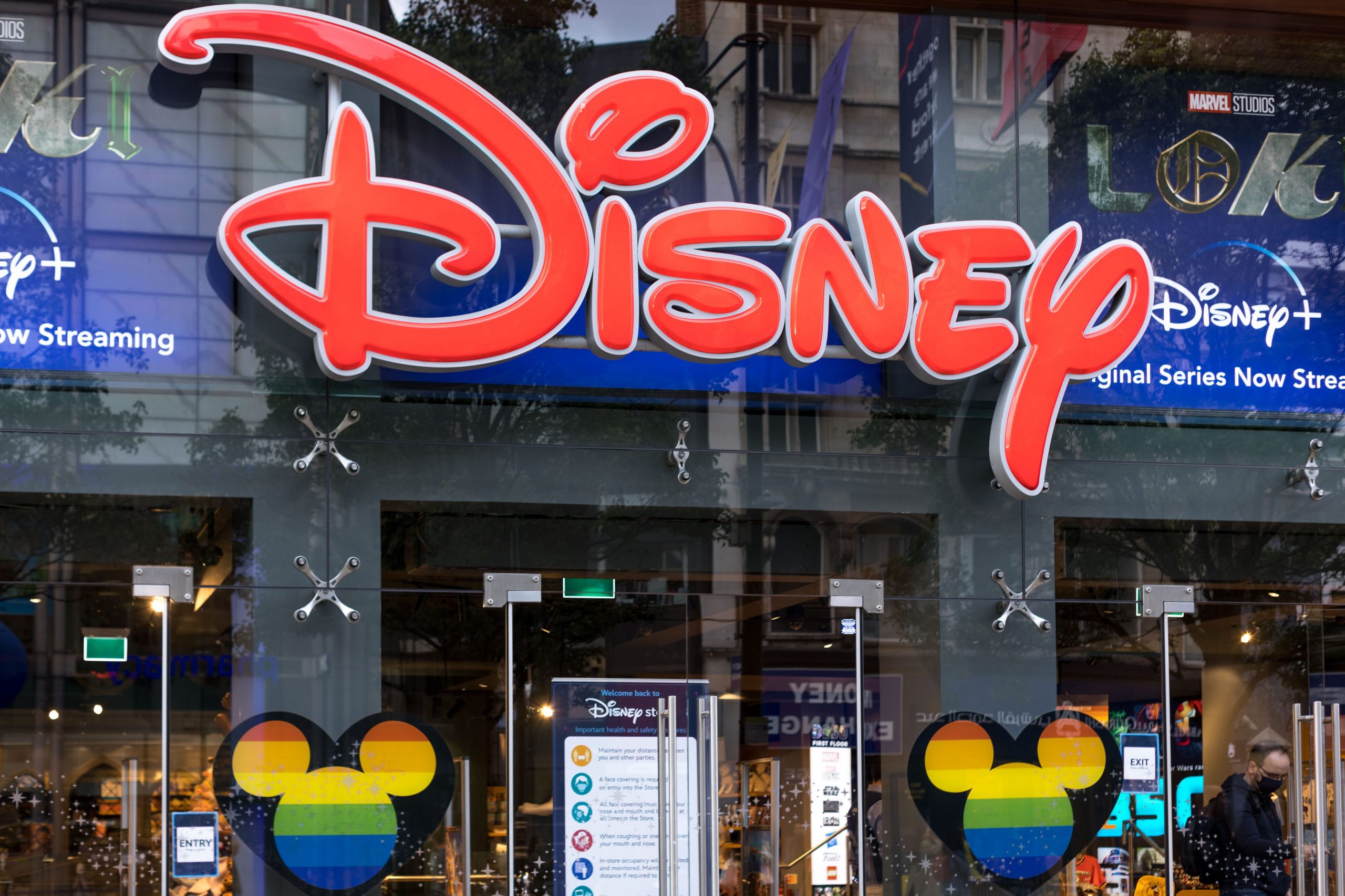 A bright red Disney logo attached to a glass-walled entrance to one of its stores.